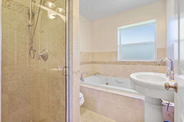 Full bath featuring a whirlpool tub and a stall shower