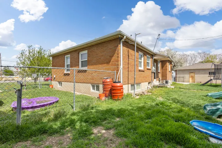 View of side of home featuring brick siding and a trampoline