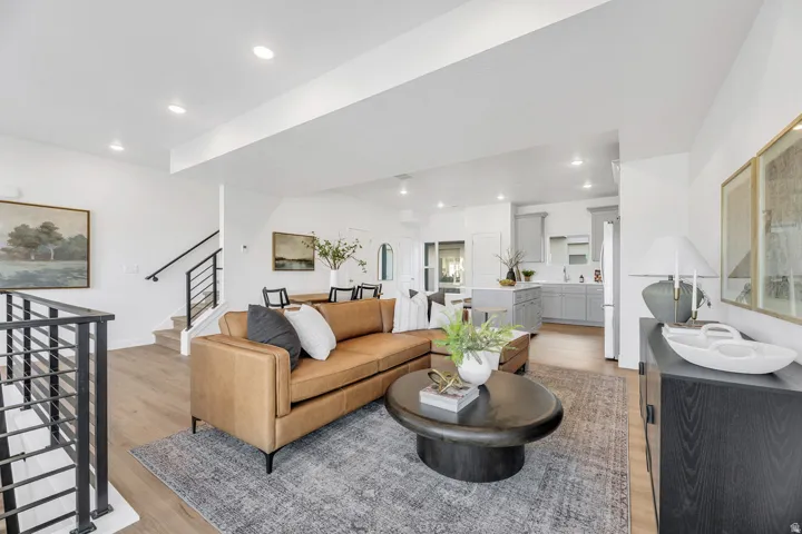 Living area with light wood finished floors and recessed lighting