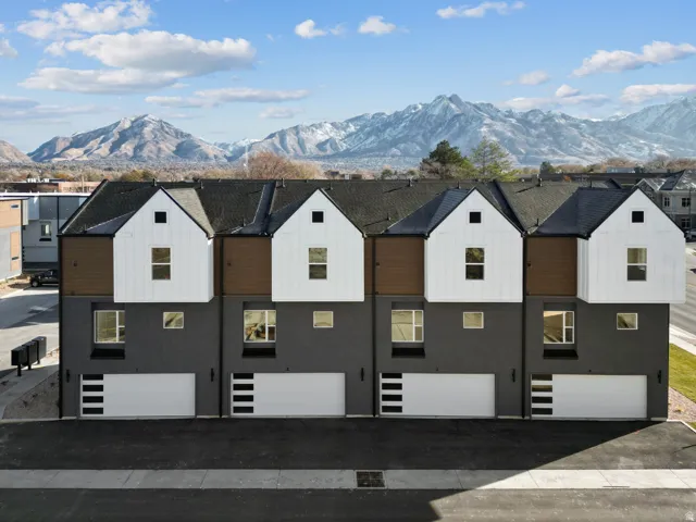 View of front of home with a mountain view, an attached garage, and stucco siding