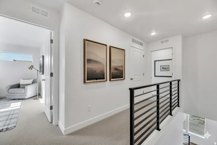 Corridor featuring an upstairs landing, light carpet, and recessed lighting