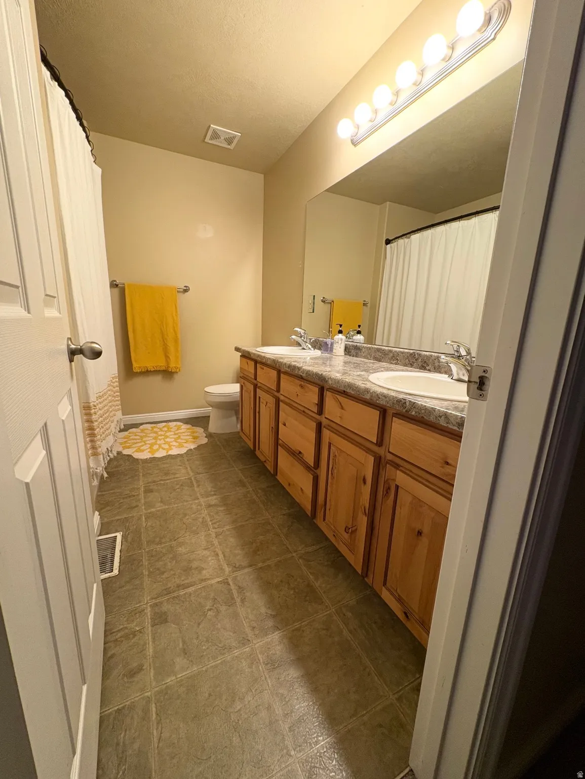 Bathroom with double vanity and curtained shower