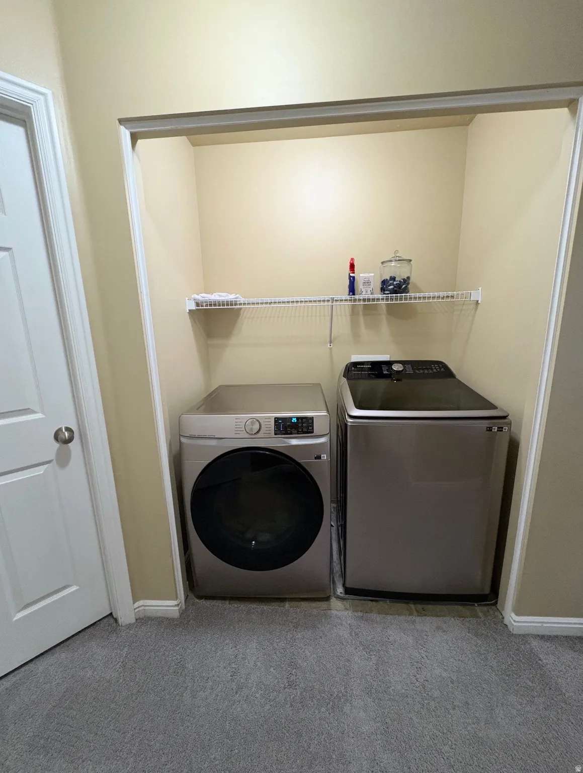 Laundry area featuring light carpet and washer and dryer