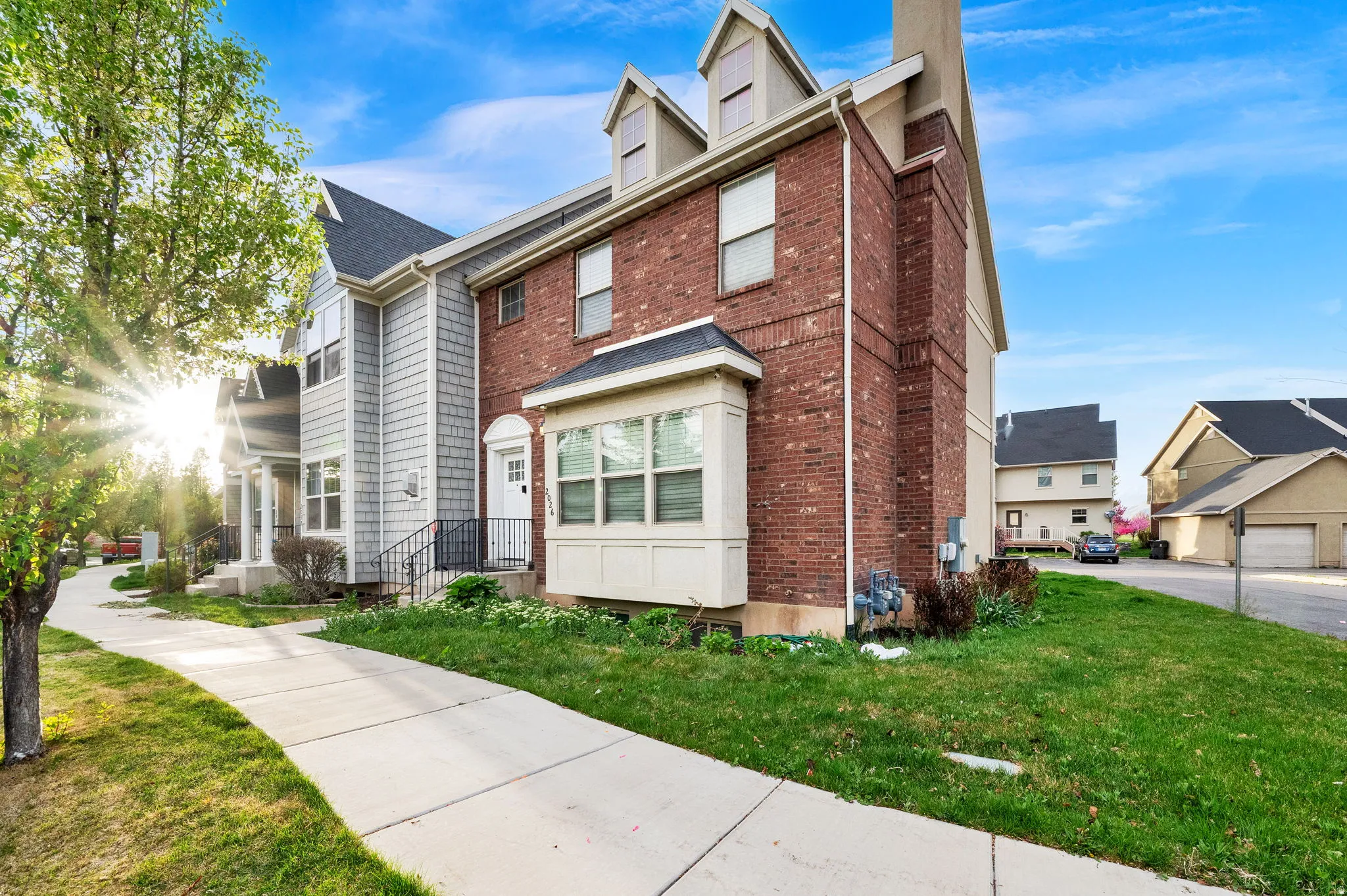 Traditional style home featuring a front yard, a chimney, and brick siding