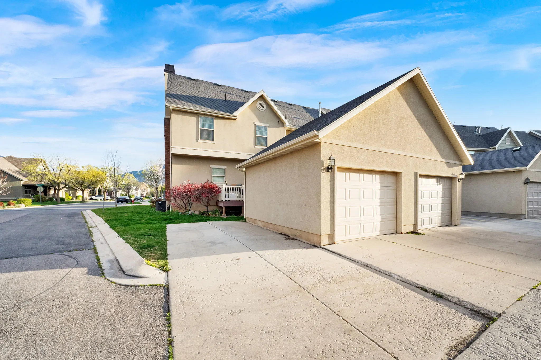 View of side of property with stucco siding, a residential view, concrete driveway, and a garage