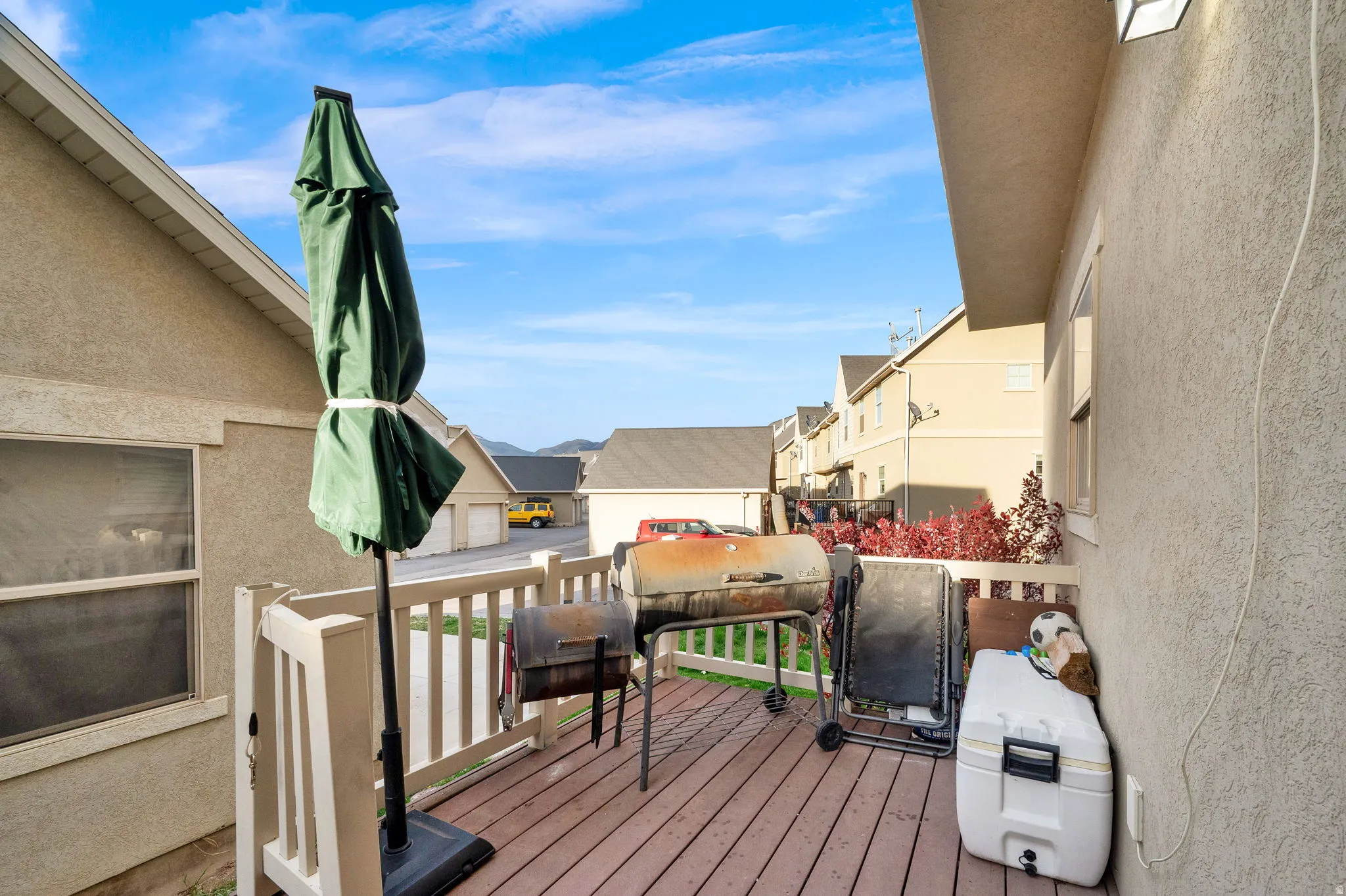 Wooden terrace with a residential view and grilling area