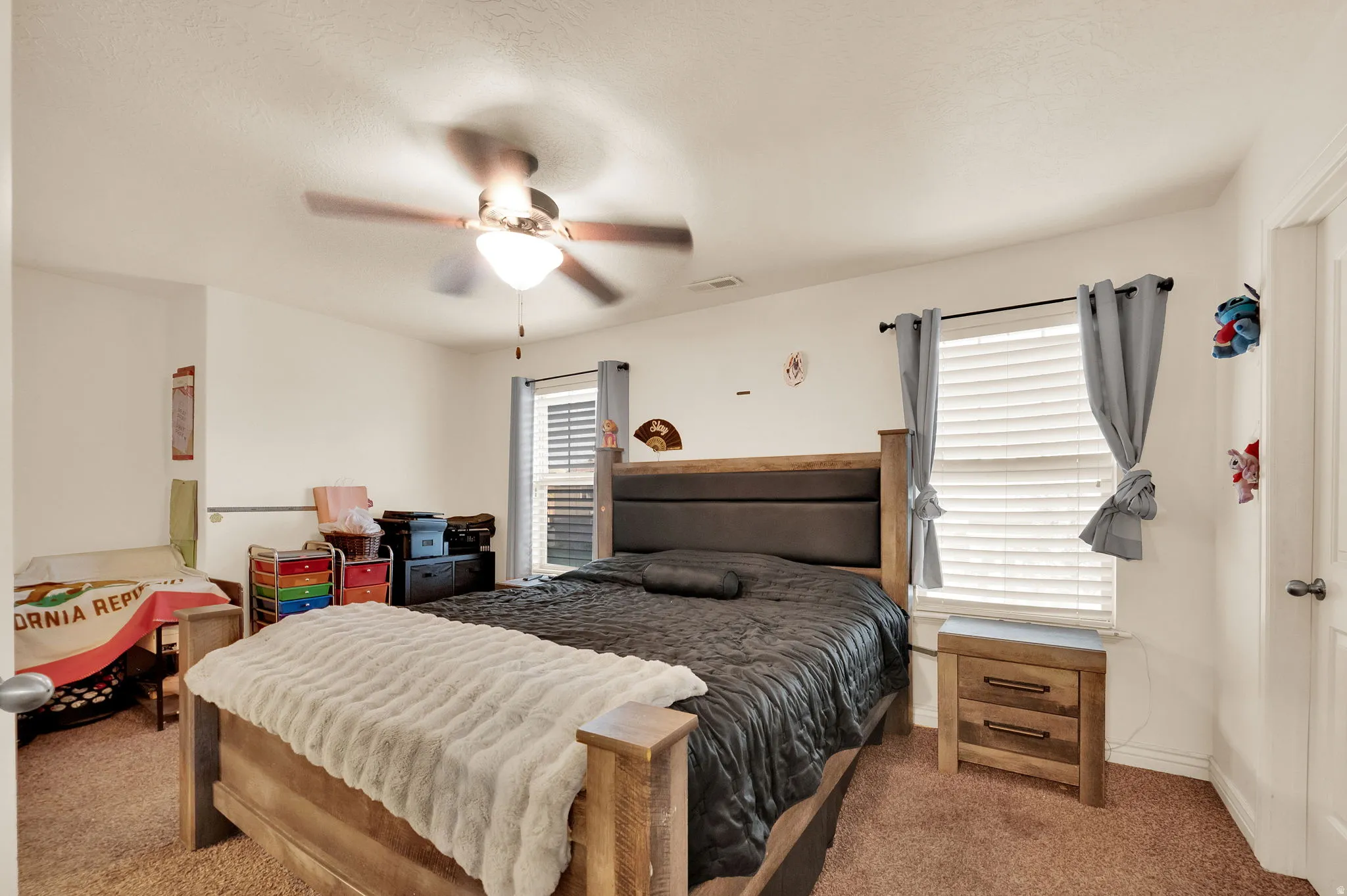 Carpeted bedroom featuring a ceiling fan and baseboards
