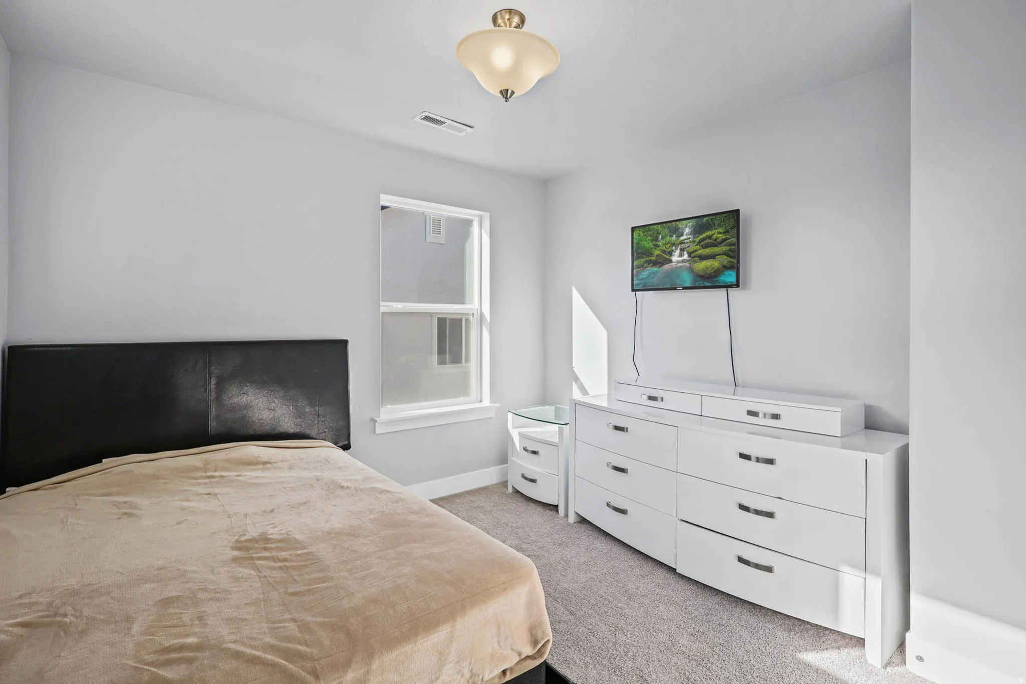 Bedroom with light carpet and baseboards