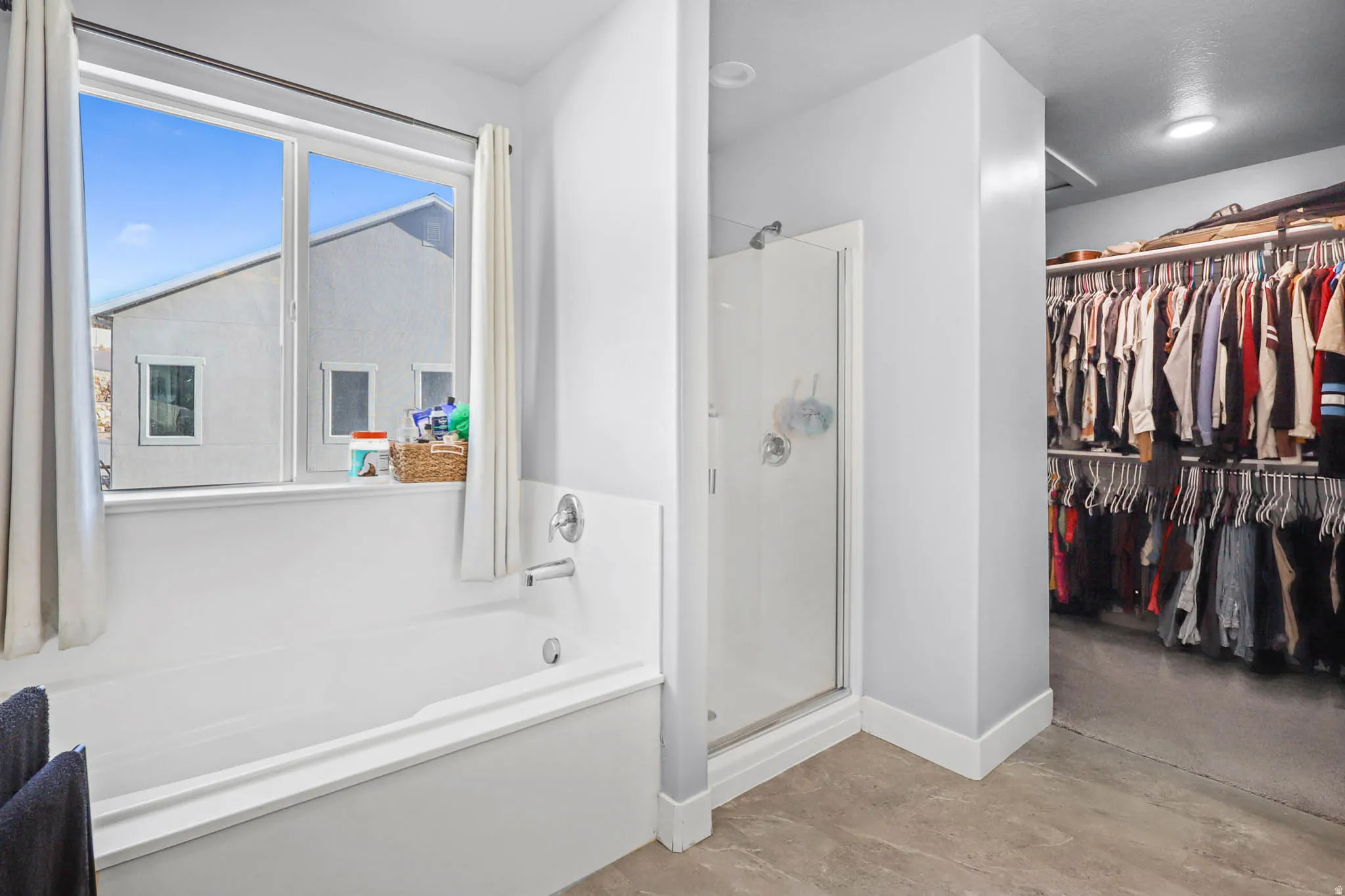 Primary Bathroom with a walk in closet, a stall shower, and a bath