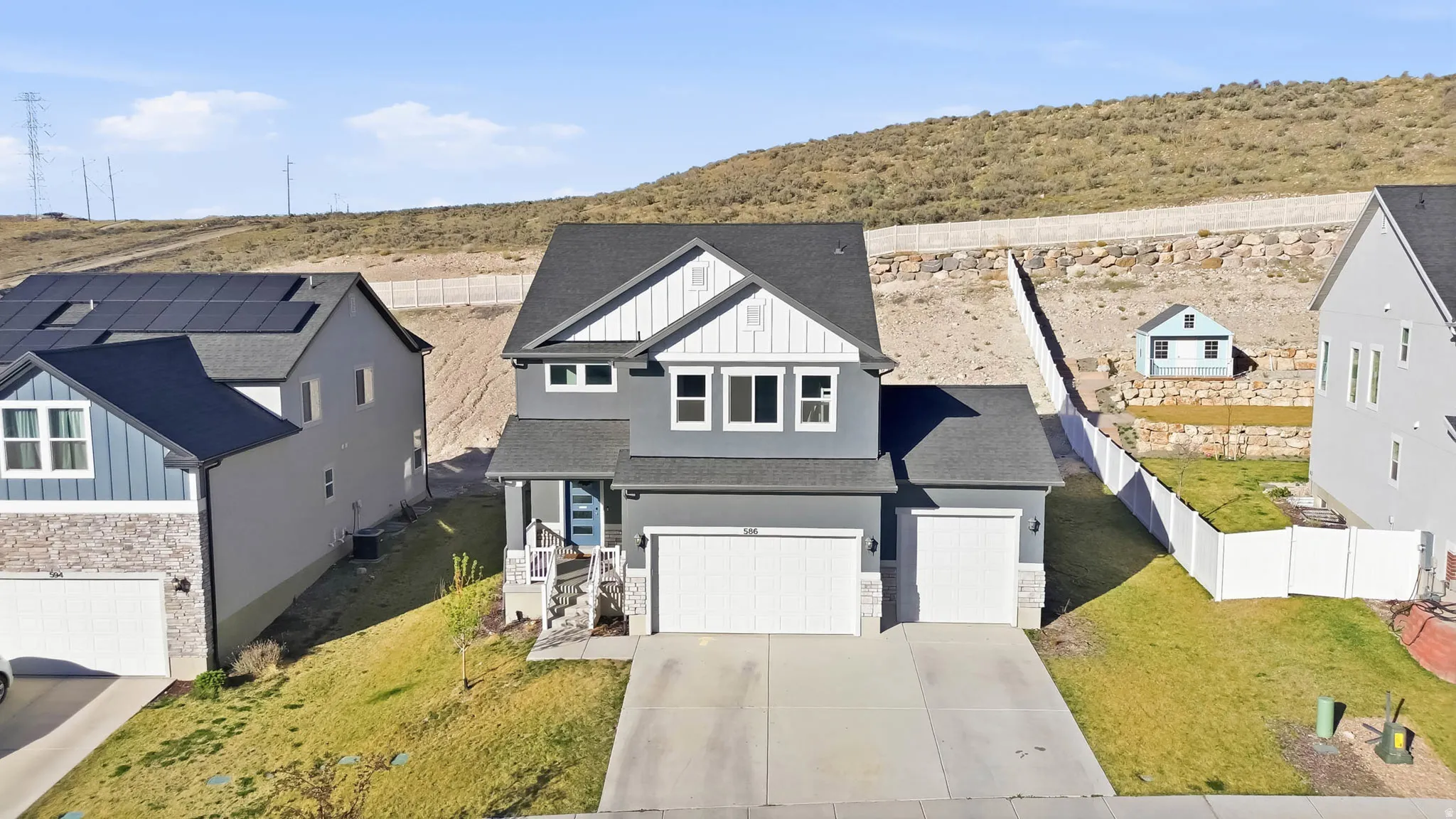 View of front of property featuring stone siding, board and batten siding, roof with shingles, driveway, and an attached garage
