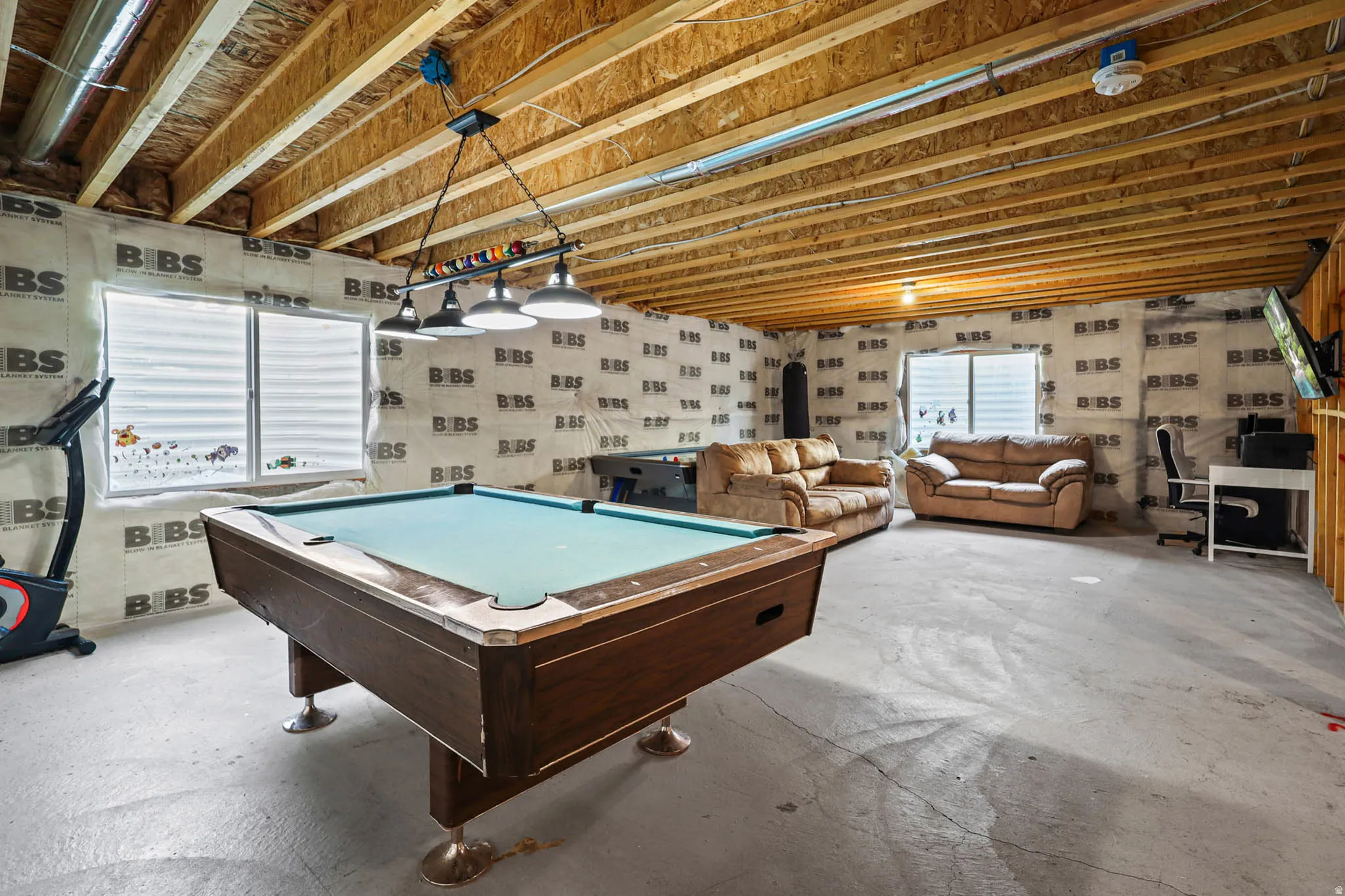 Playroom featuring unfinished concrete flooring and billiards