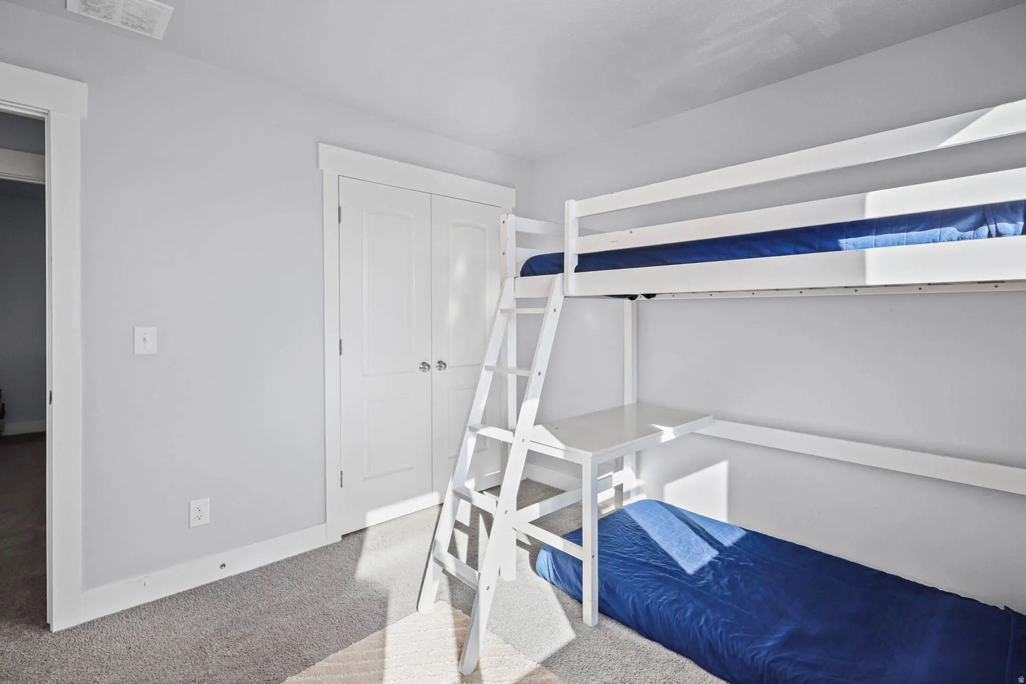 Bedroom with light carpet and a closet