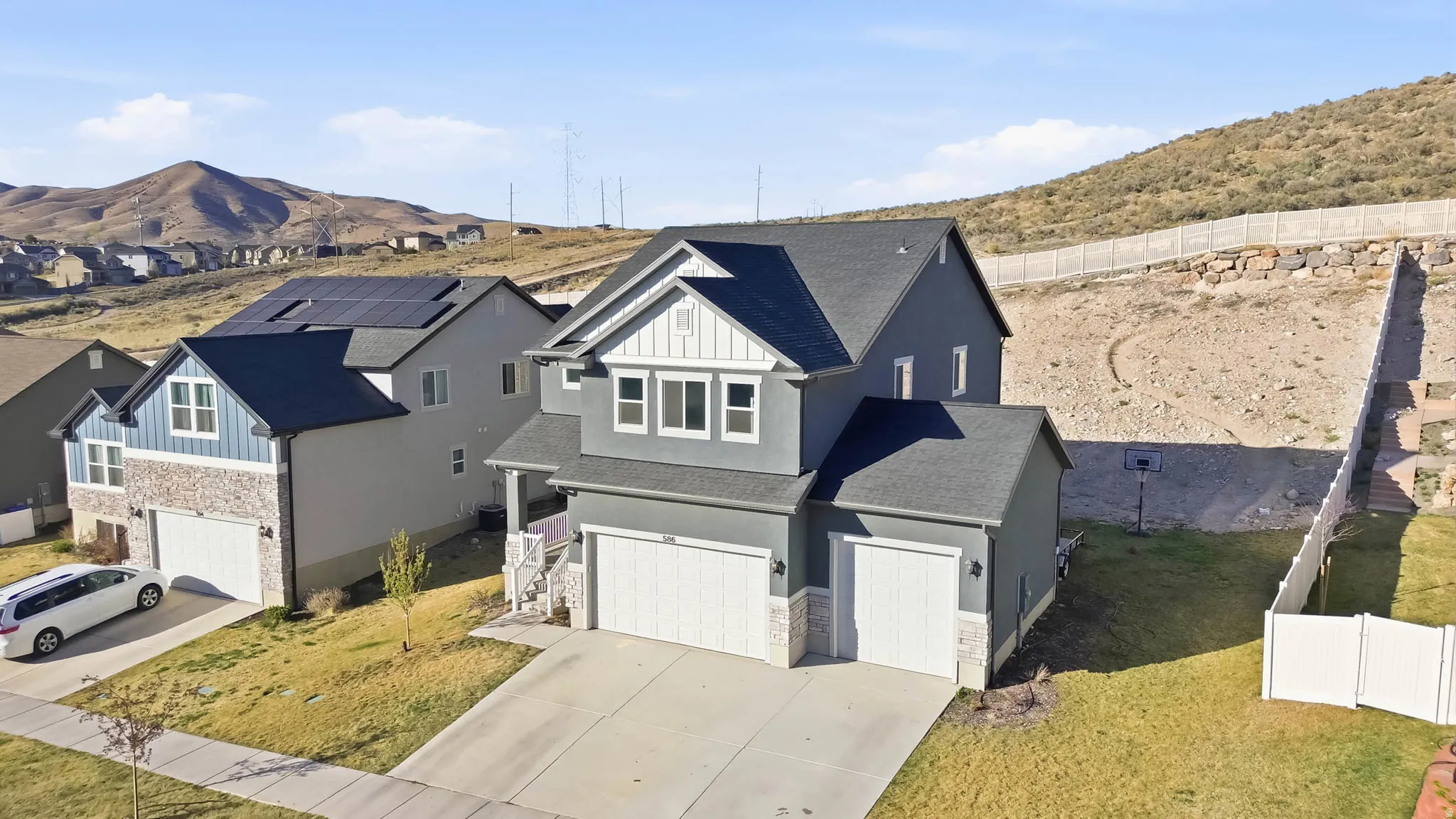 View of front of property featuring a 3-car garage, stucco siding, stone siding, concrete driveway, and a shingled roof