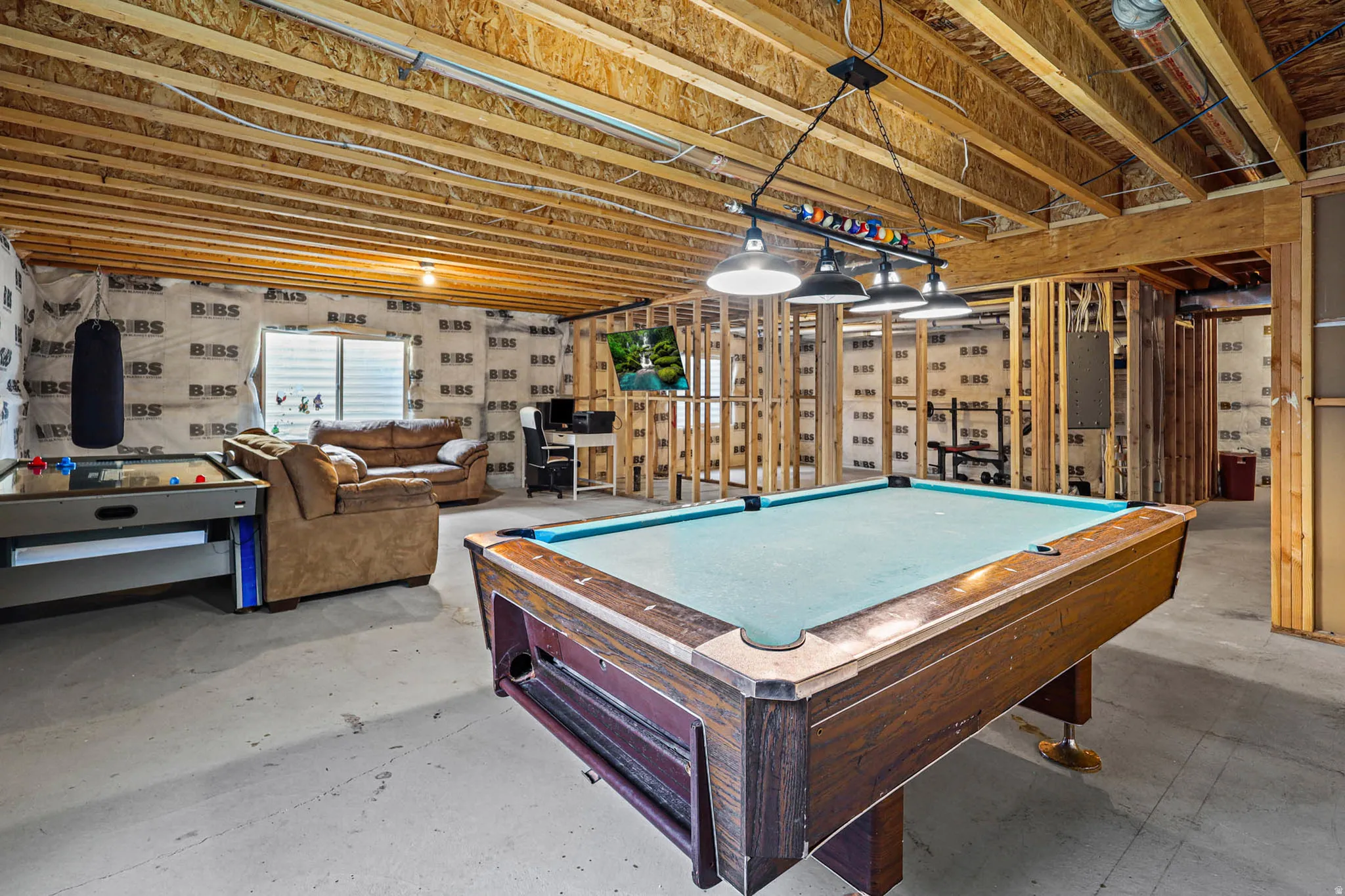 Rec room with unfinished concrete floors and pool table