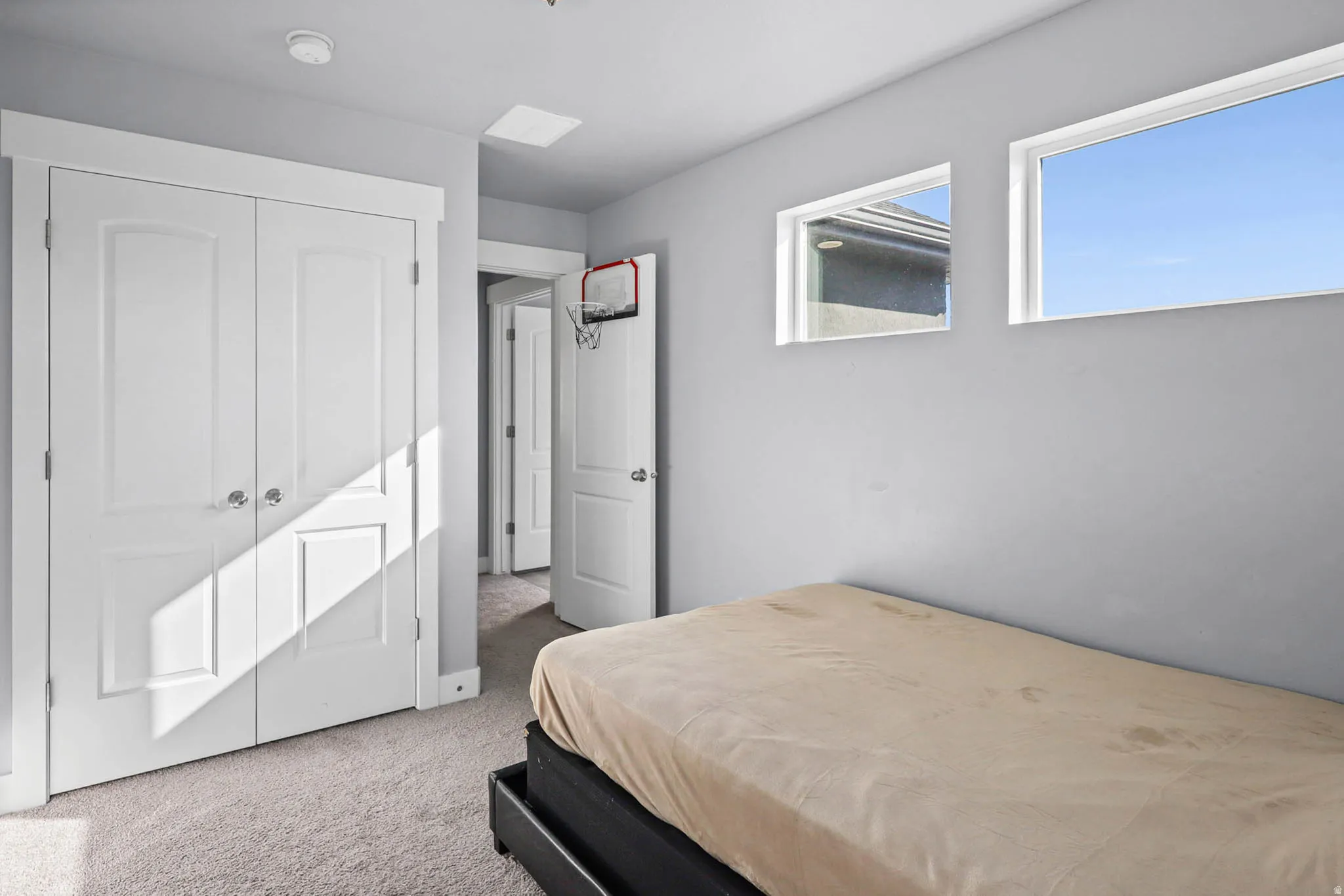 Bedroom featuring light colored carpet and a closet