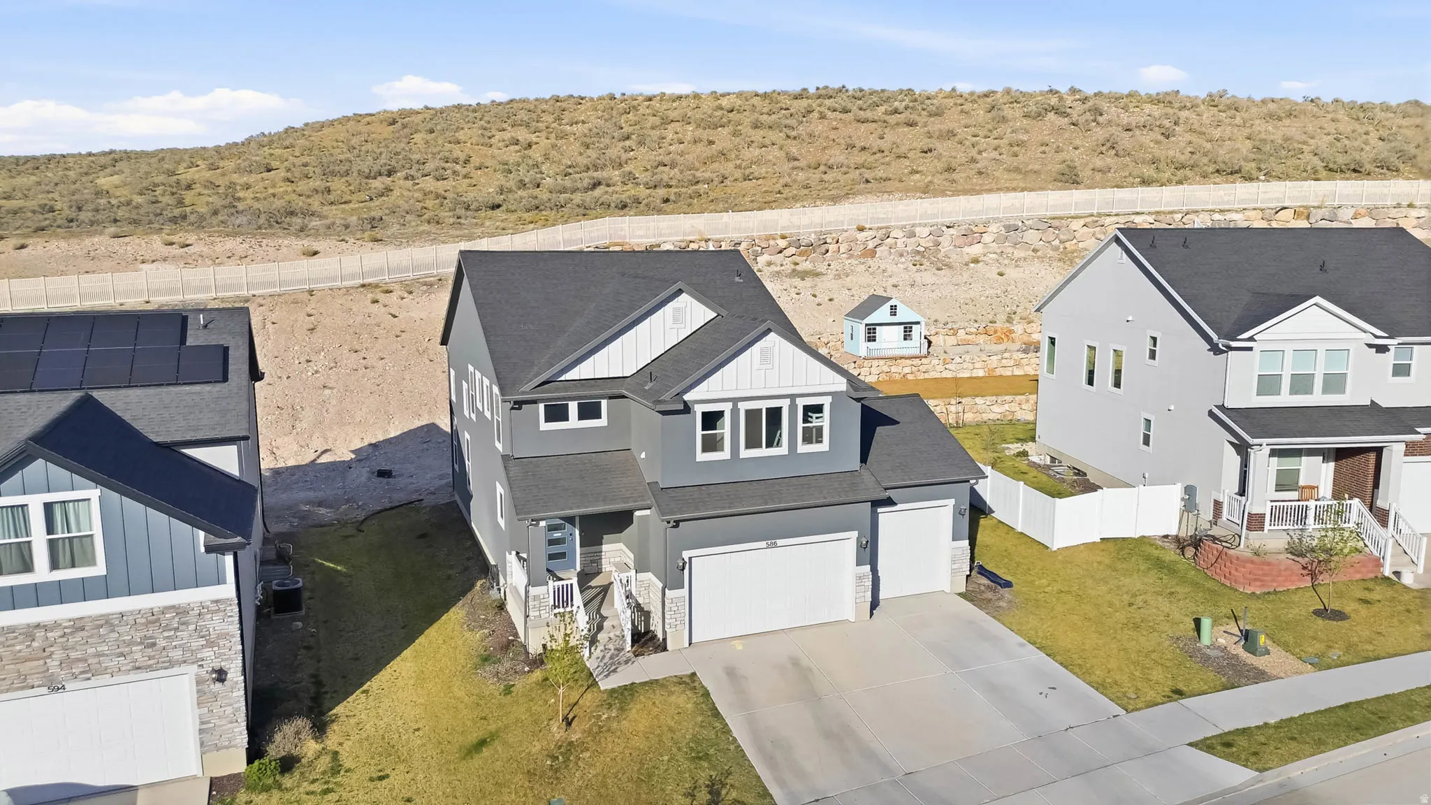 View of front of property featuring board and batten siding, stone siding, concrete driveway, a 3-car garage, and a shingled roof