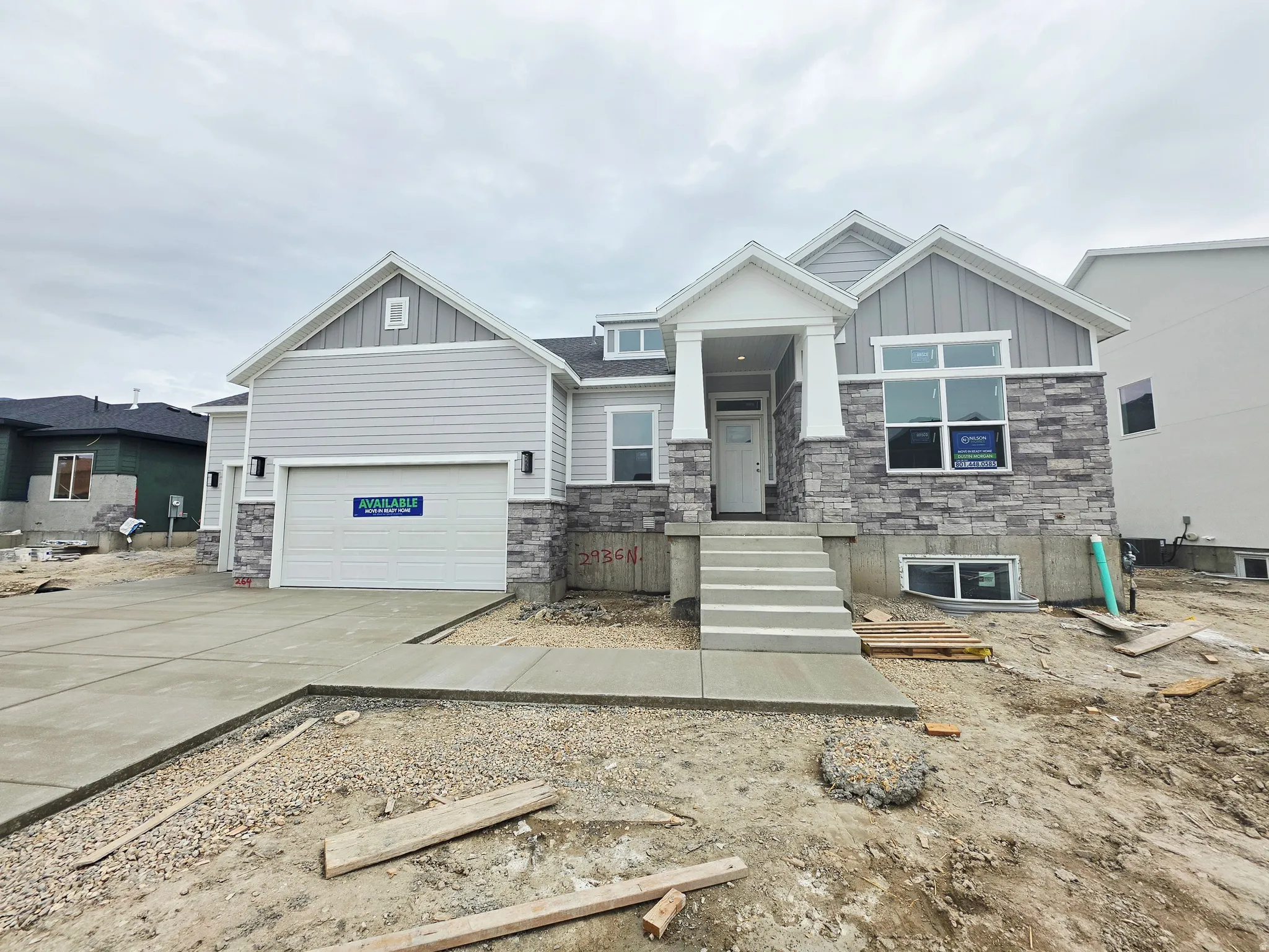 Contemporary exterior with light gray siding and stone facade accents