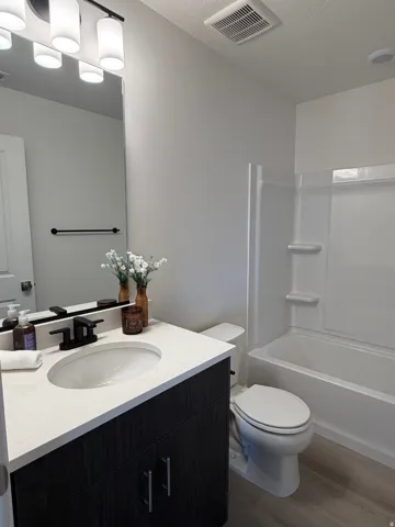 Modern bathroom featuring a vanity with a light-colored countertop and dark wood-finish cabinetry