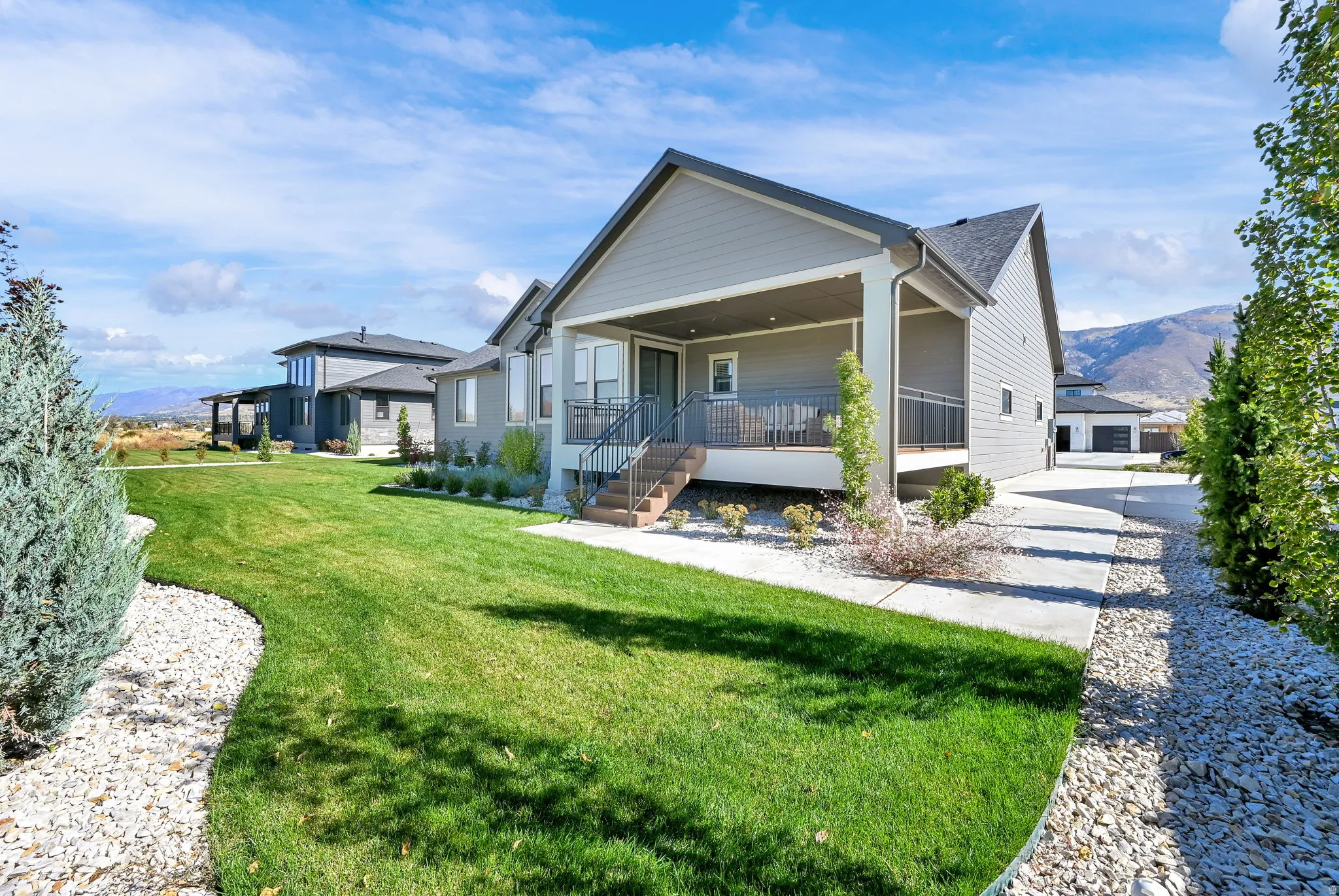Rear view of property featuring covered porch, a lawn, and a mountain view