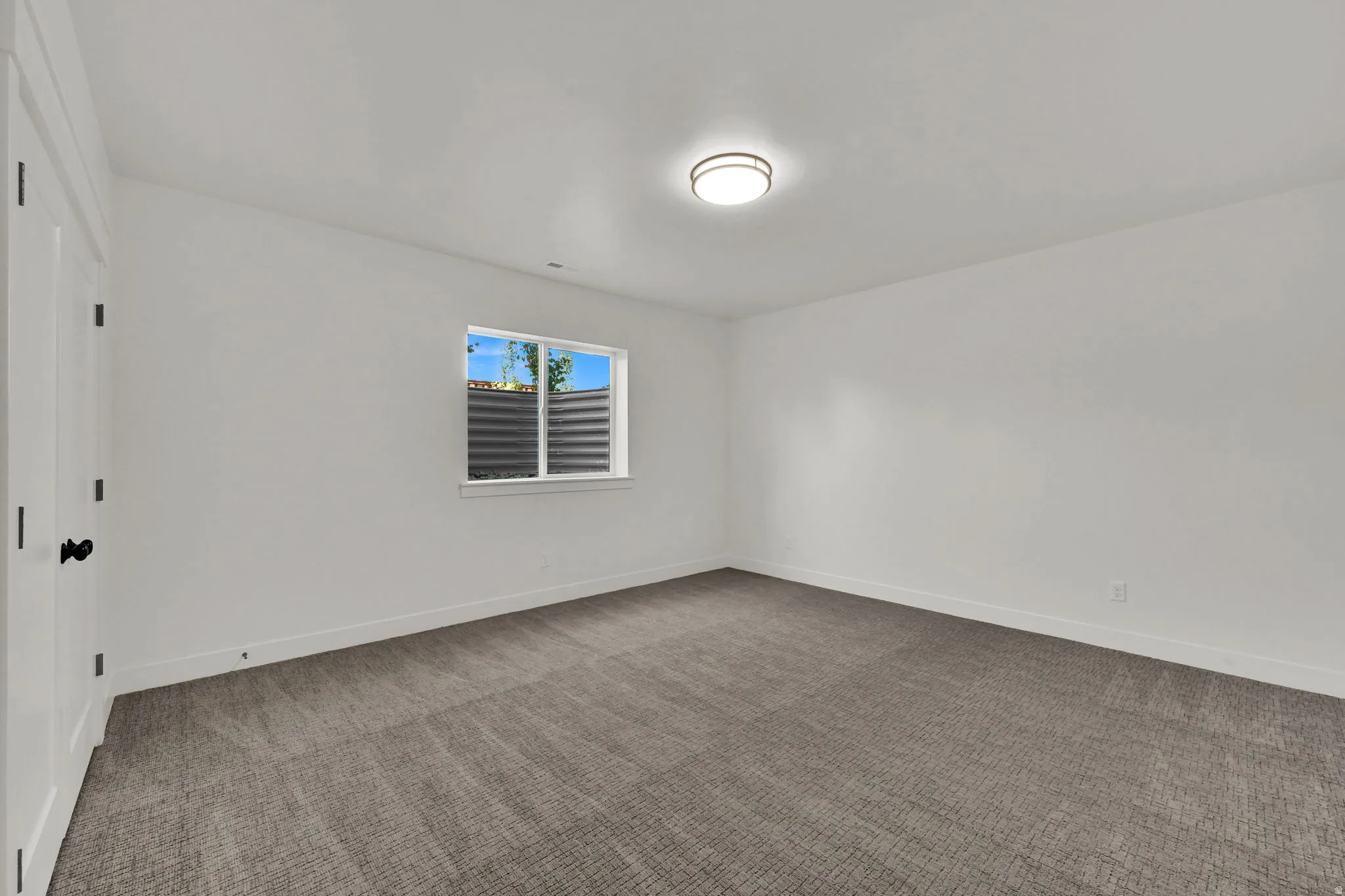 Carpeted empty room featuring baseboards