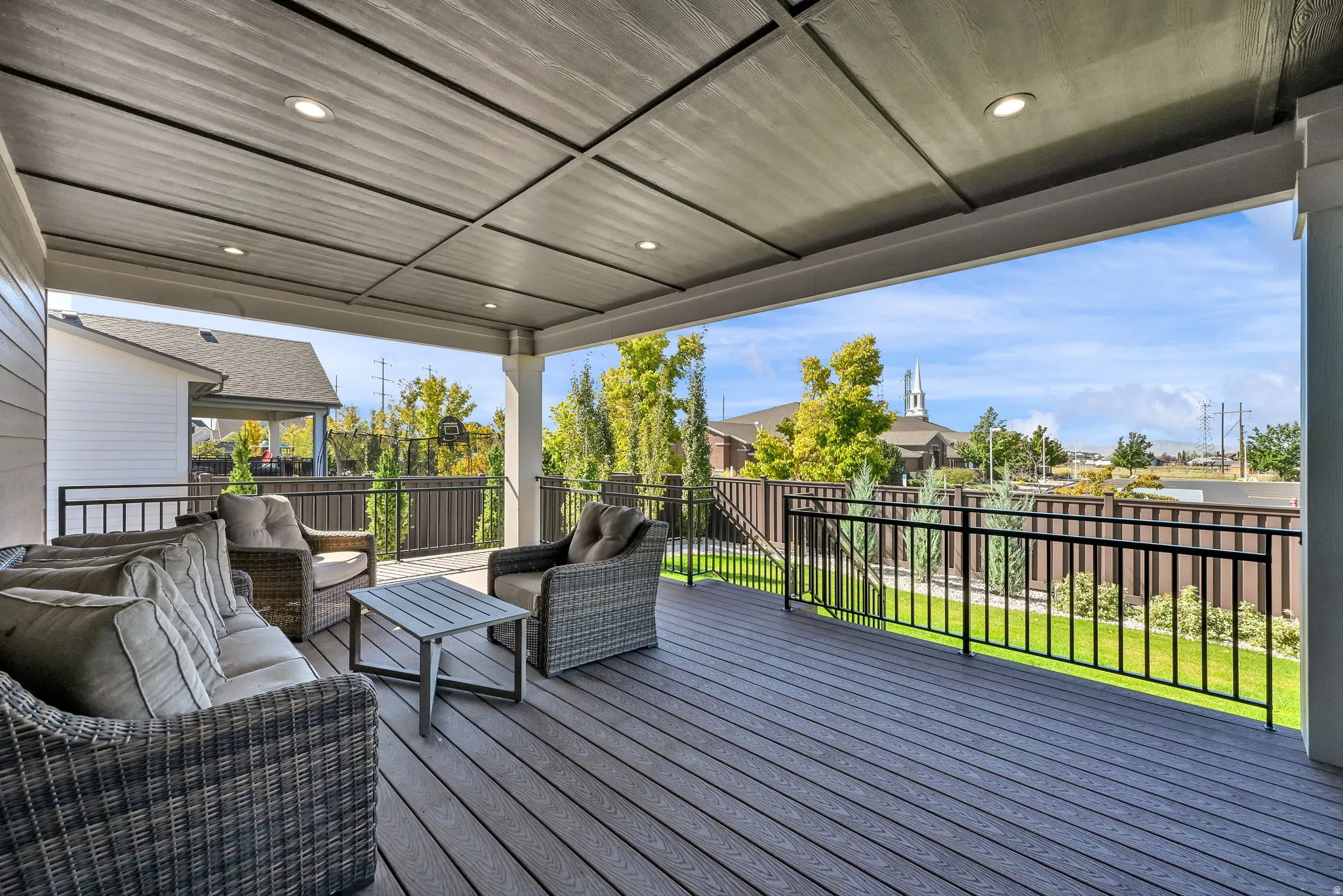 Wooden terrace featuring a fenced backyard, outdoor lounge area, and a residential view