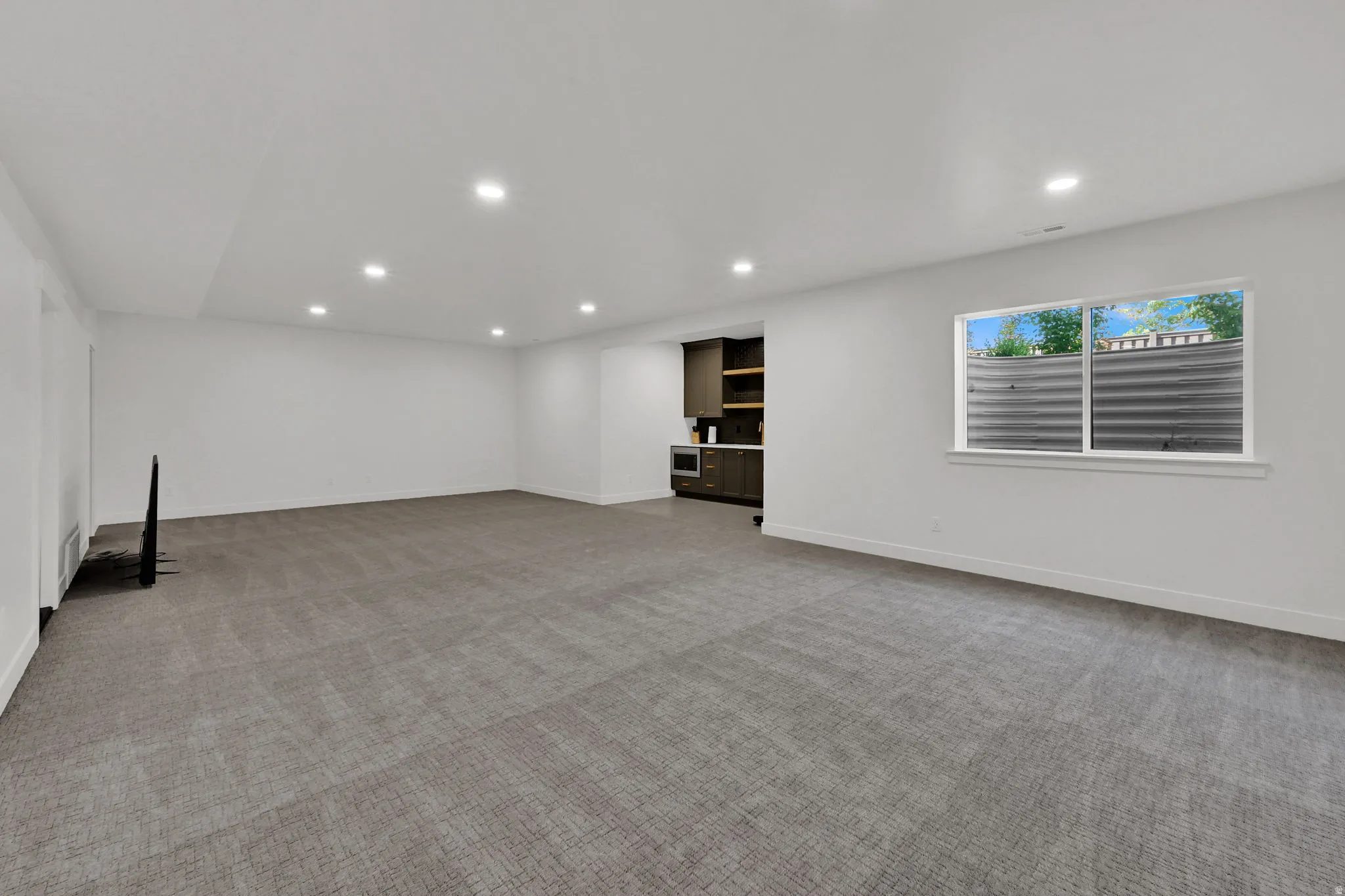 Unfurnished living room featuring light colored carpet and recessed lighting
