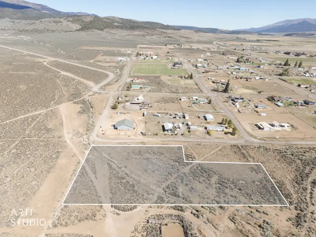 Aerial view of property and surrounding area featuring mountains, rural landscape, and property parcel outlined