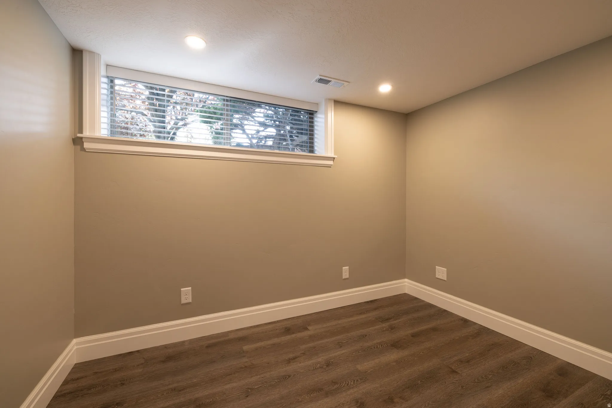 Spare room featuring dark wood finished floors and recessed lighting