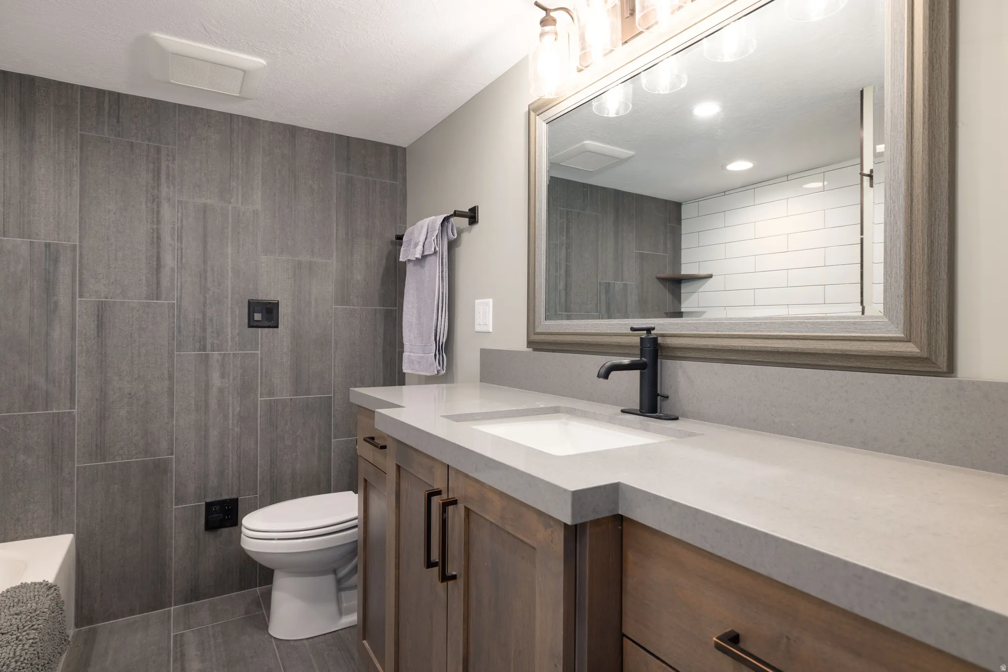 Bathroom featuring vanity and dark tile patterned floors