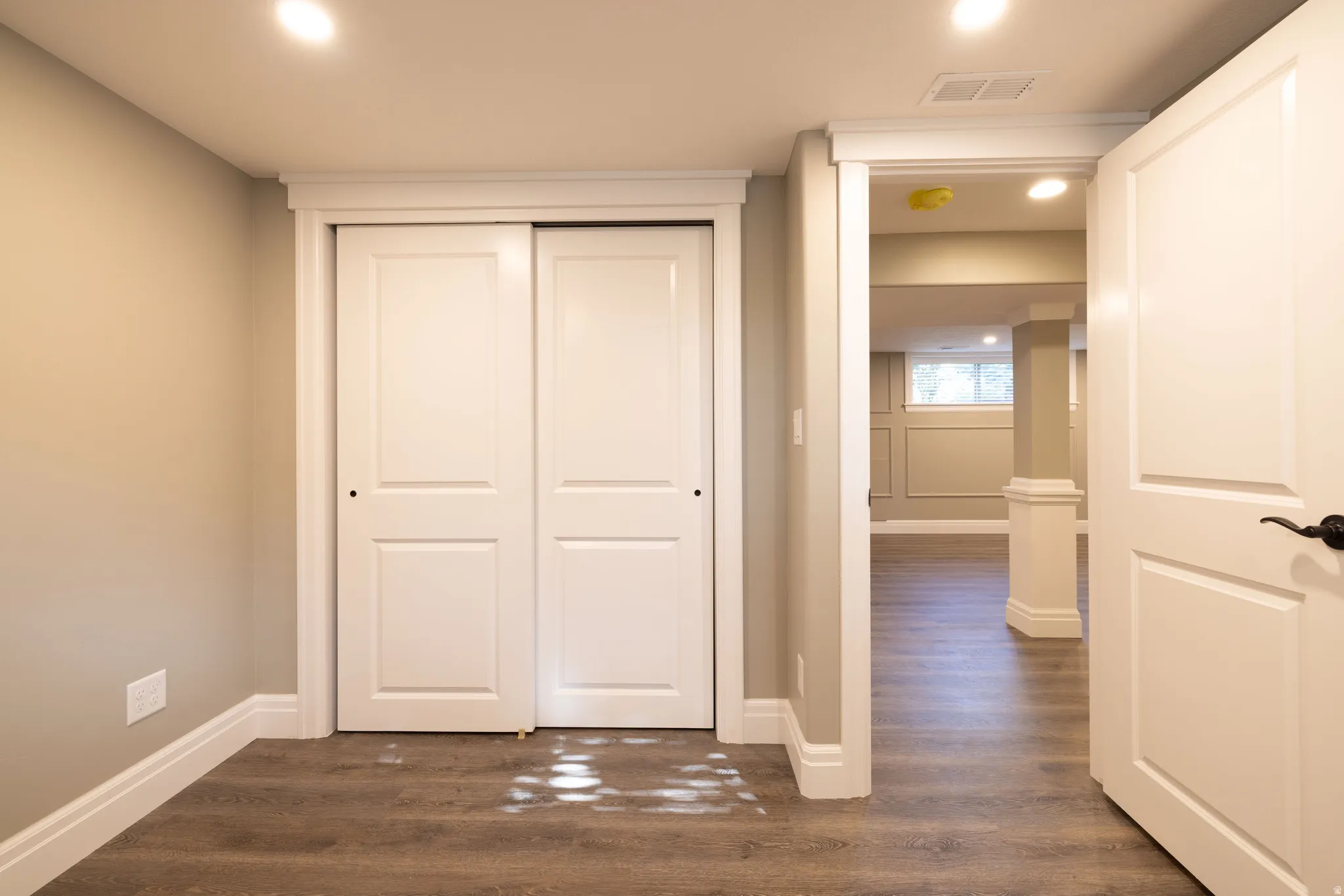 Hallway with dark wood-style flooring and recessed lighting