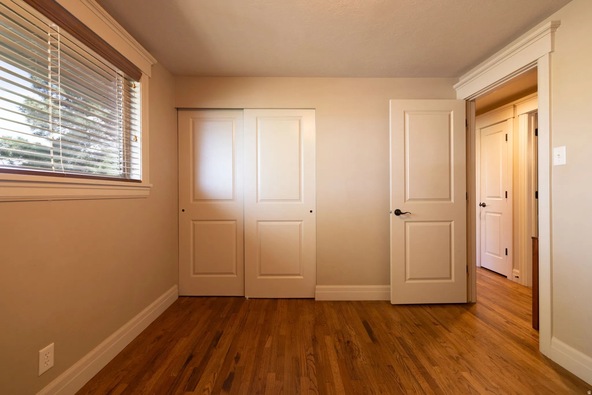 Unfurnished bedroom featuring wood finished floors and a closet
