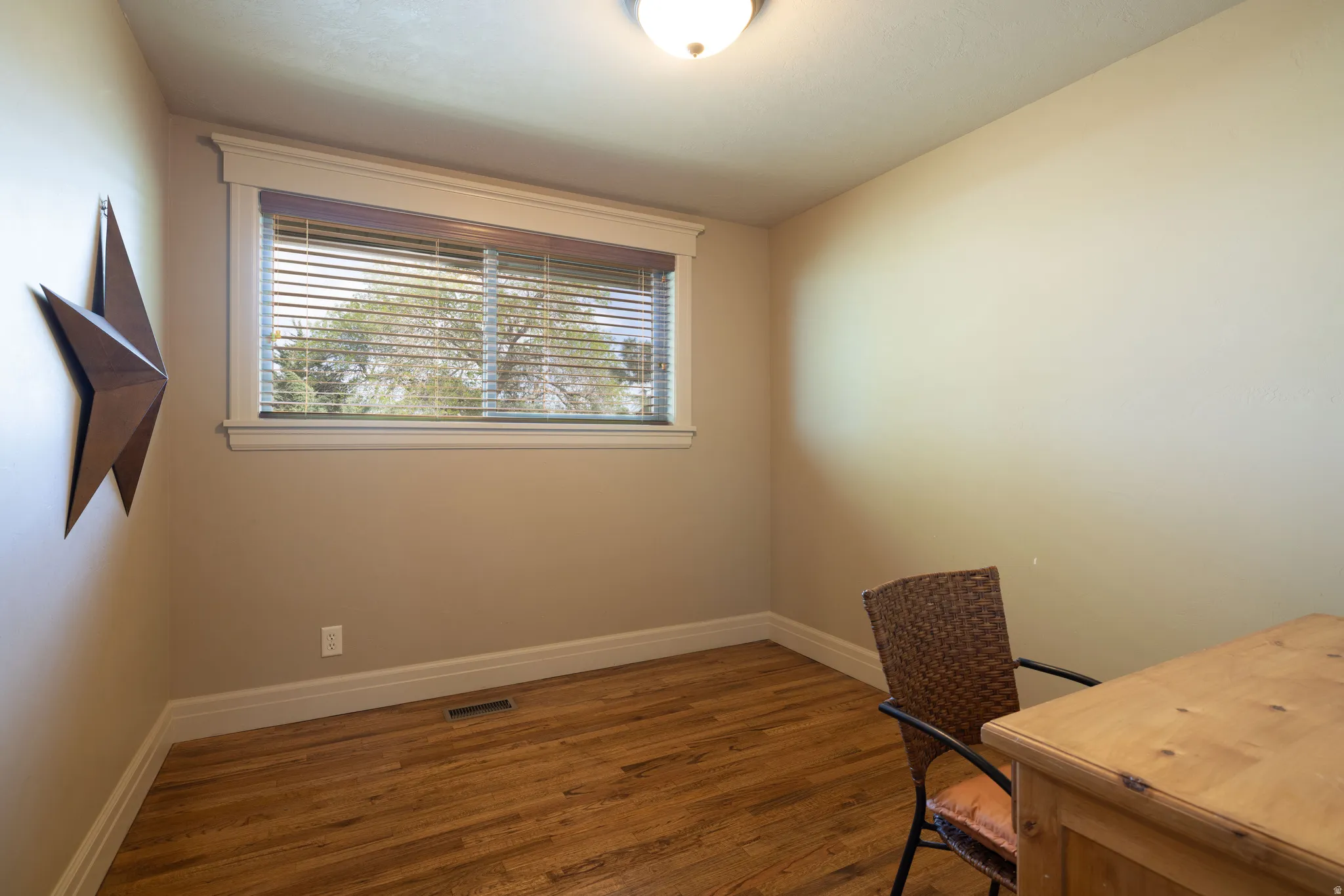 Office with dark wood-style flooring and baseboards