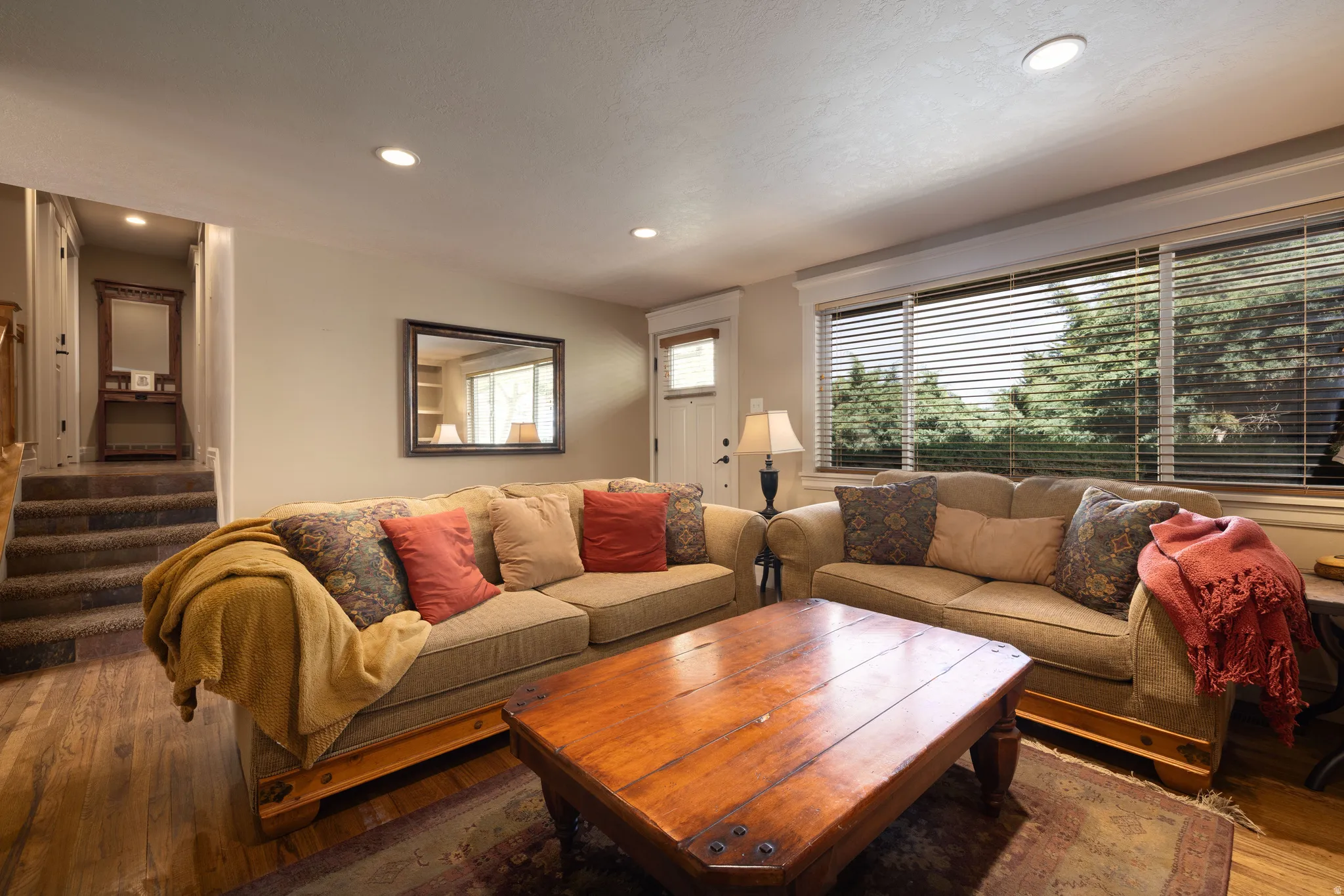 Living room with hardwood flooring, plenty of natural light, and recessed lighting