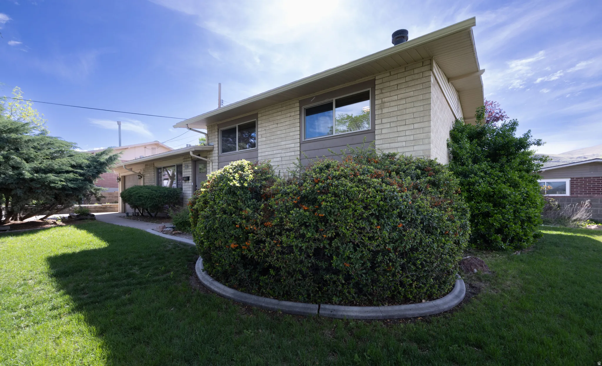 View of home featuring a yard and brick siding