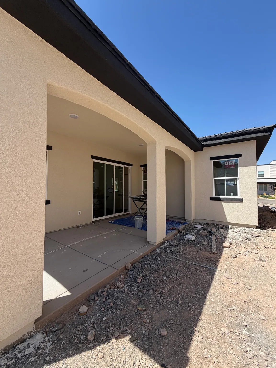 Covered patio with recessed lighting, stucco exterior, black trim accents, and sliding glass door access