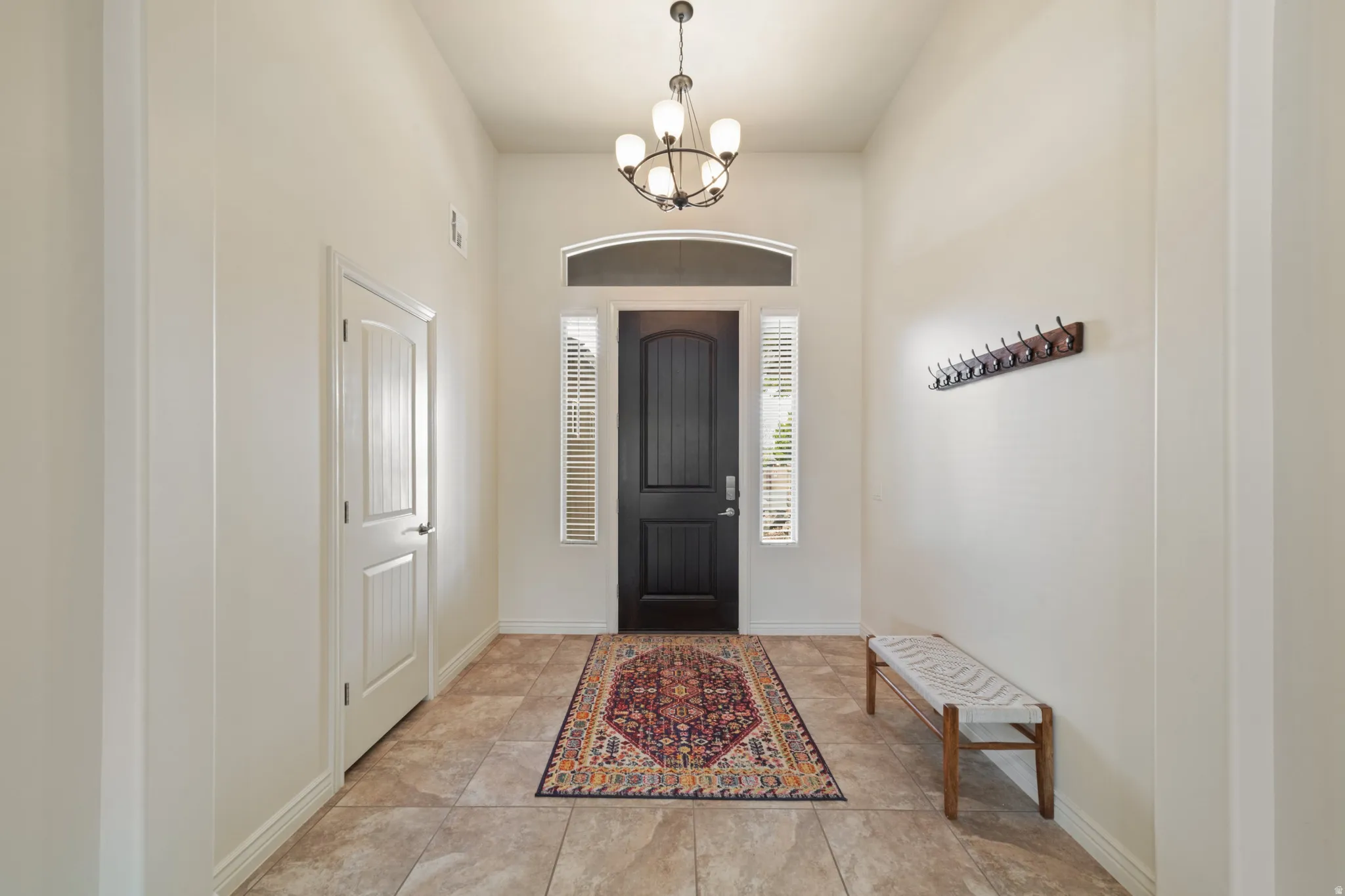 Entryway with a chandelier and baseboards