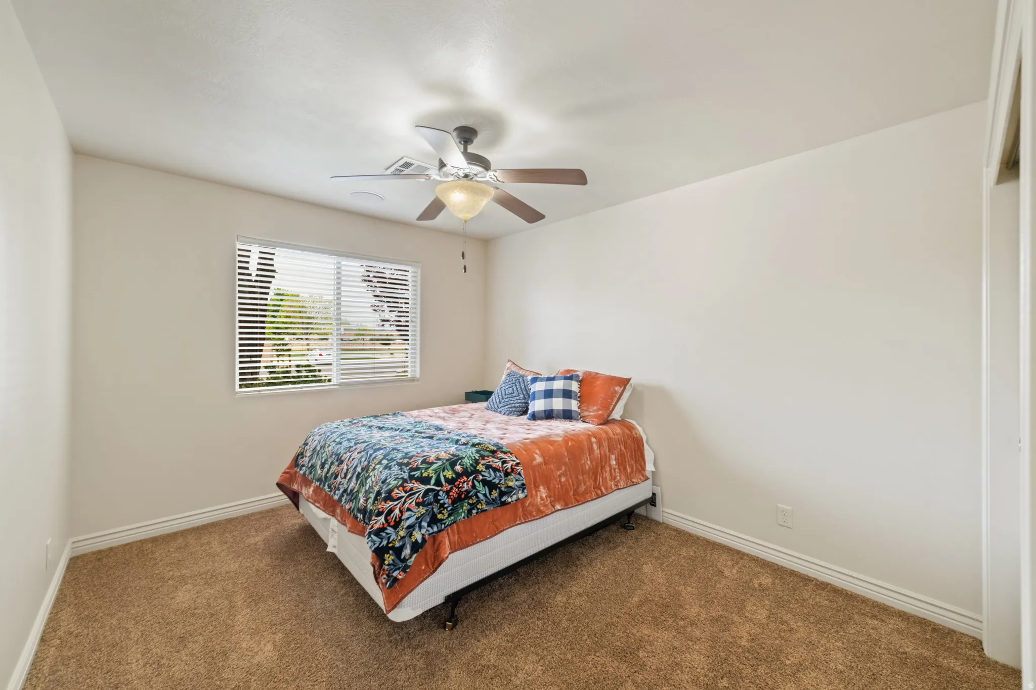 Carpeted bedroom featuring baseboards and ceiling fan
