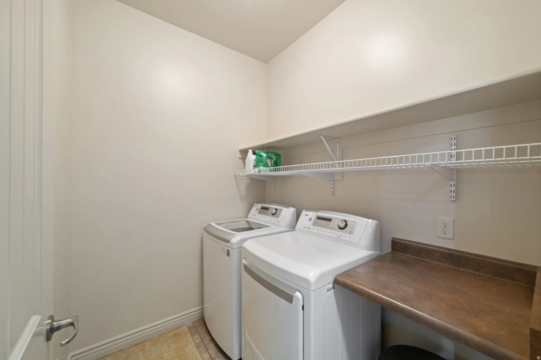 Laundry room featuring washer and clothes dryer and light tile patterned floors
