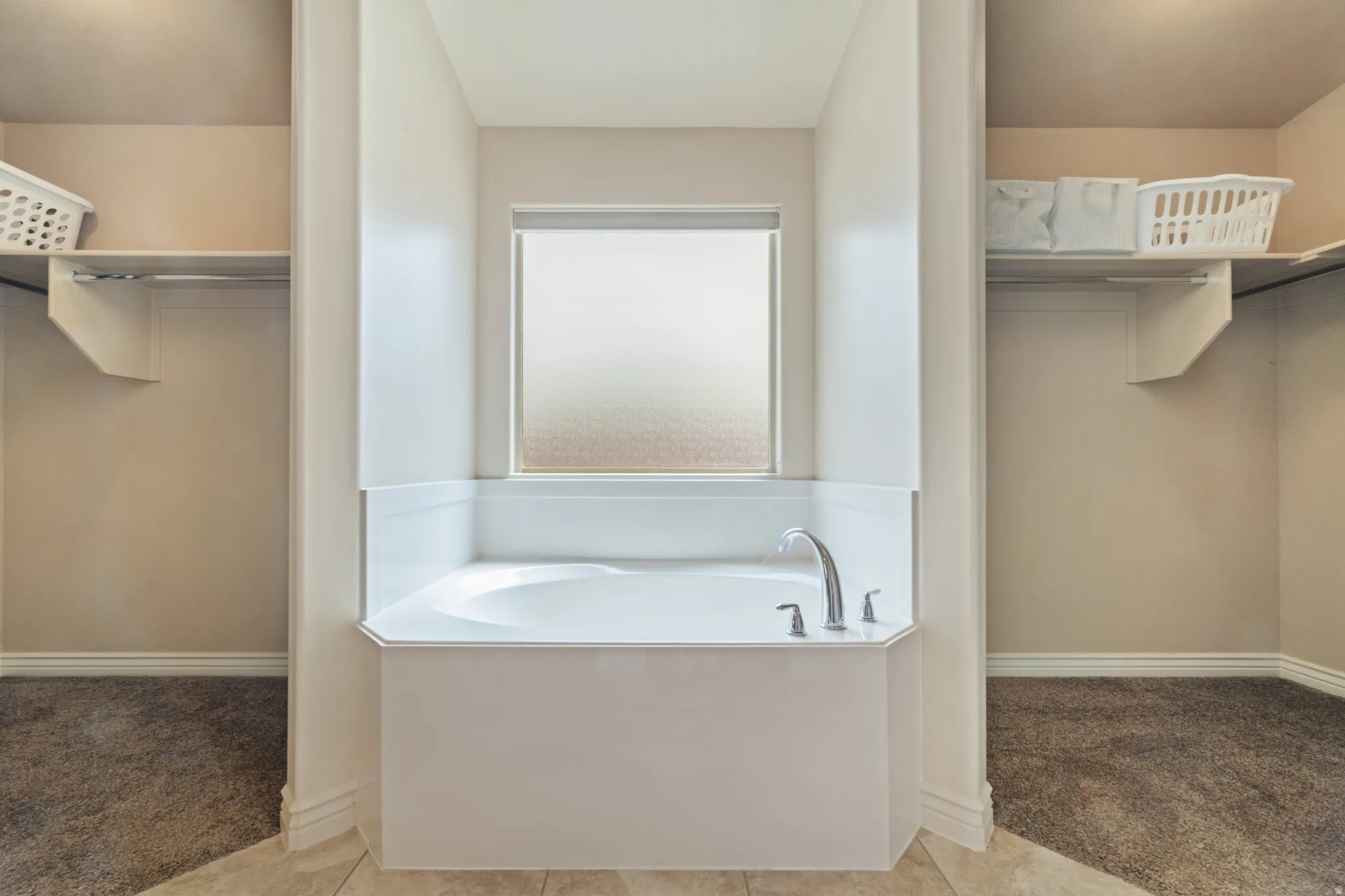 Full bath featuring light colored carpet, a spacious closet, and a garden tub