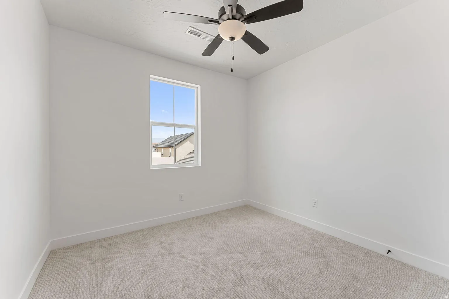 Unfurnished room featuring light colored carpet and ceiling fan