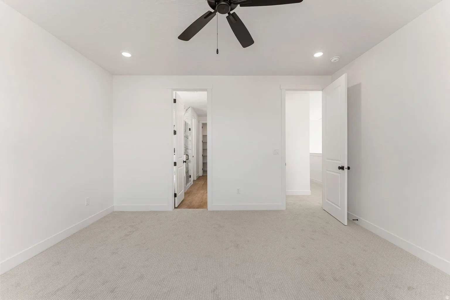 Unfurnished bedroom featuring light carpet, recessed lighting, and ceiling fan
