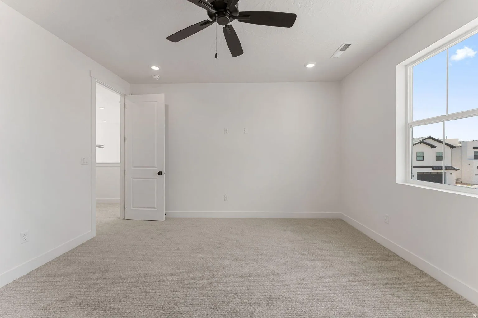 Empty room featuring light carpet, ceiling fan, and recessed lighting