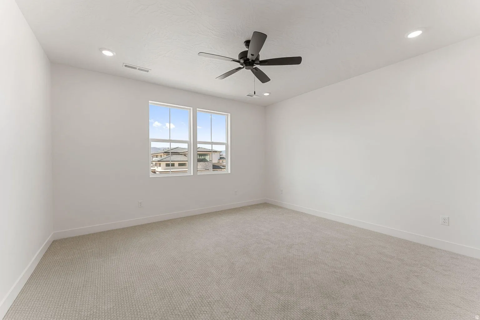 Spare room featuring carpet floors, ceiling fan, and recessed lighting