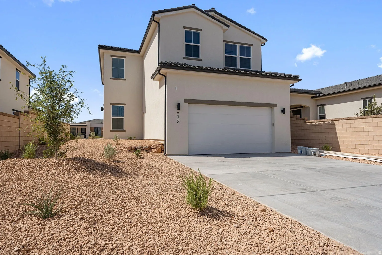 Mediterranean / spanish-style house with driveway, a tiled roof, stucco siding, and a garage