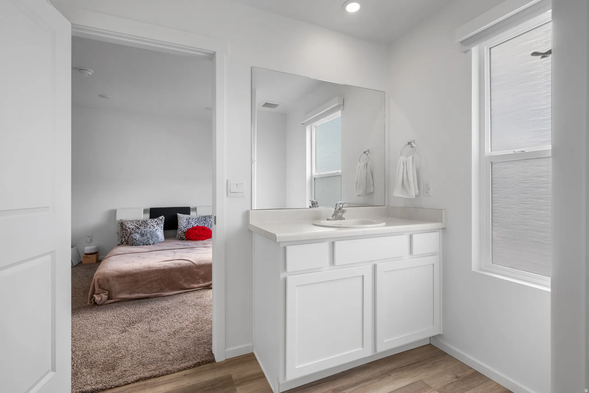 Bathroom featuring connected bathroom, vanity, and light wood-style flooring