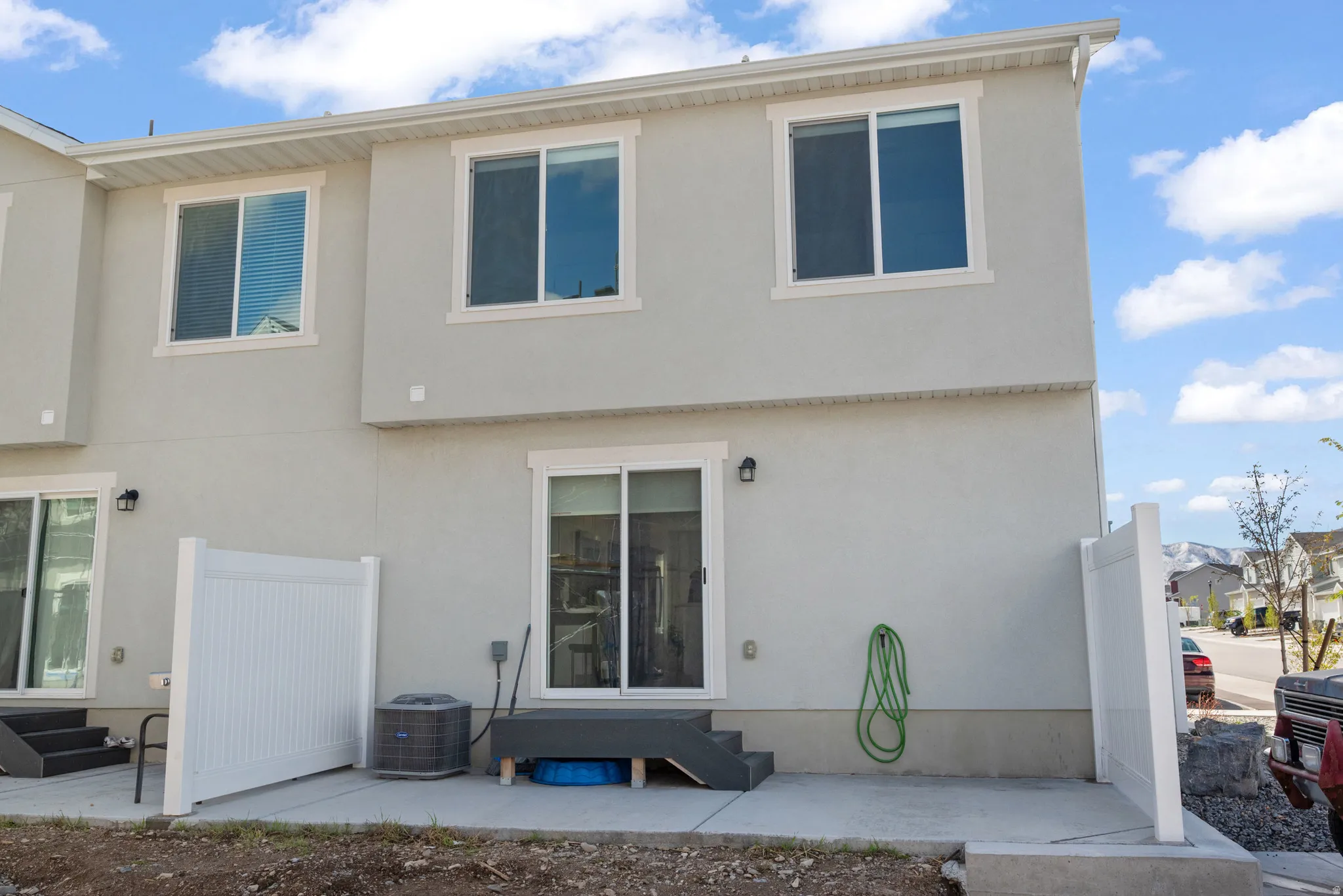 Rear view of property featuring entry steps and stucco siding