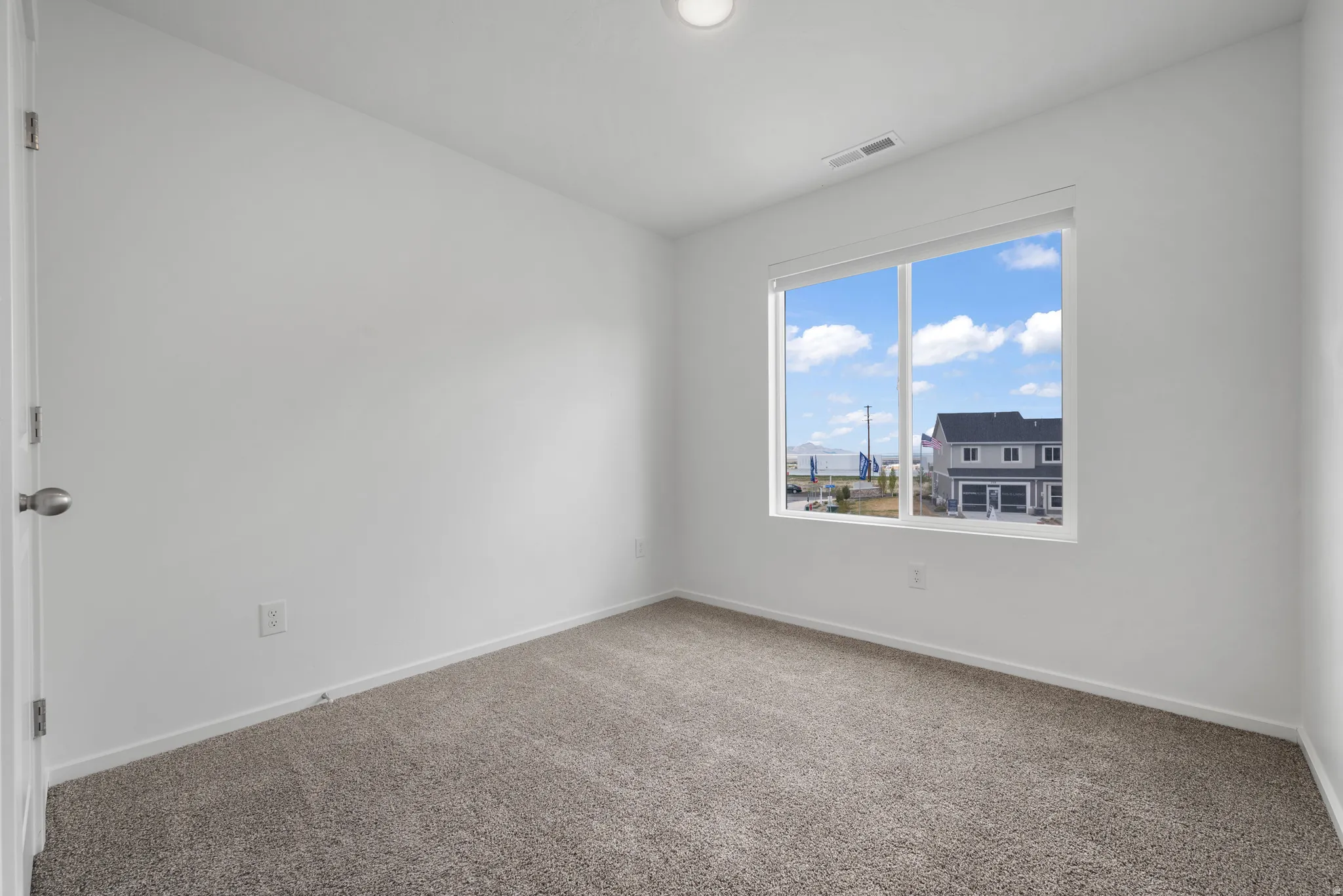 Carpeted spare room featuring baseboards