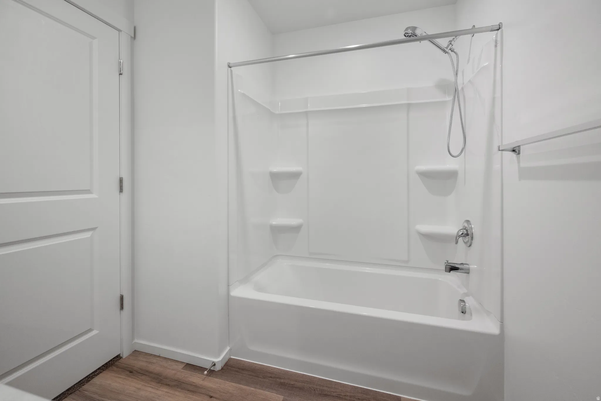 Full bath with dark wood finished floors and shower / washtub combination