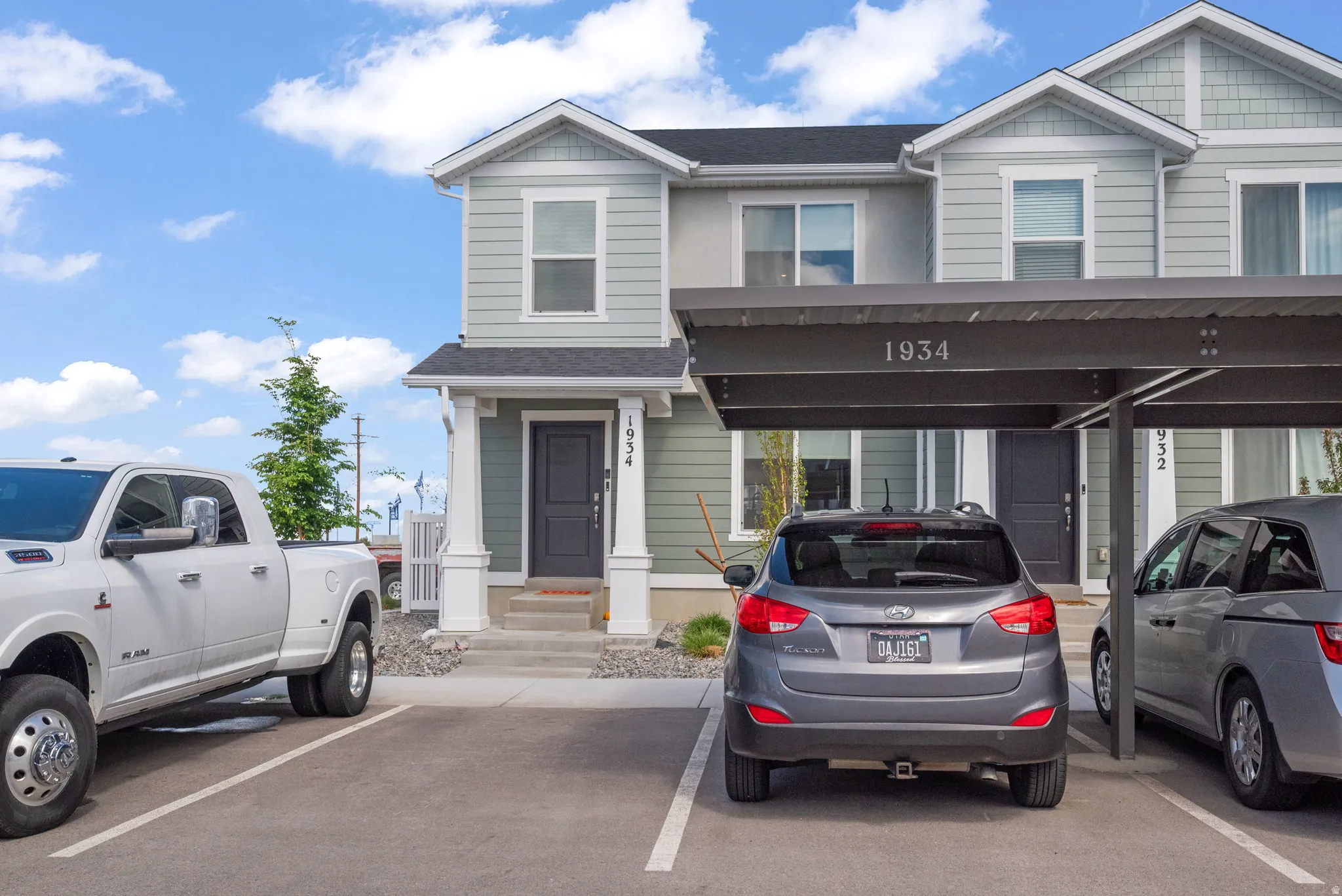 View of front facade featuring covered parking and a shingled roof