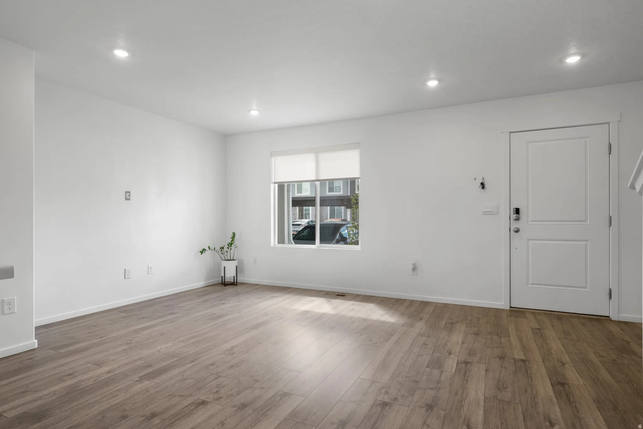 Unfurnished living room featuring dark wood-style flooring and recessed lighting